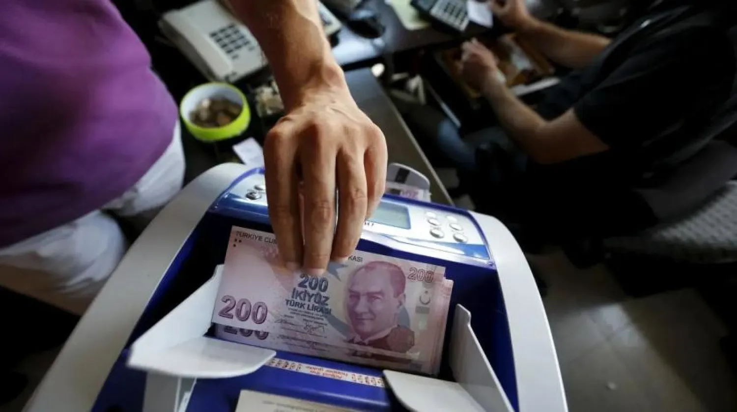 A file photo shows a money changer uses a machine to count Turkish liras in the border city of Hatay, Turkey. (Reuters)
