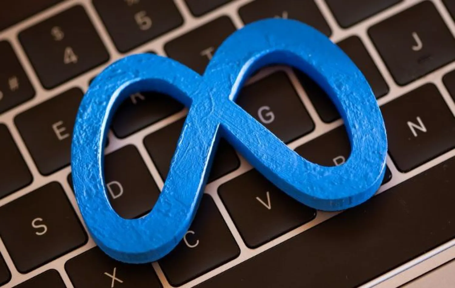 A 3D printed Facebook's new rebrand logo Meta is placed on laptop keyboard in this illustration taken on November 2, 2021. REUTERS/Dado Ruvic/Illustration

