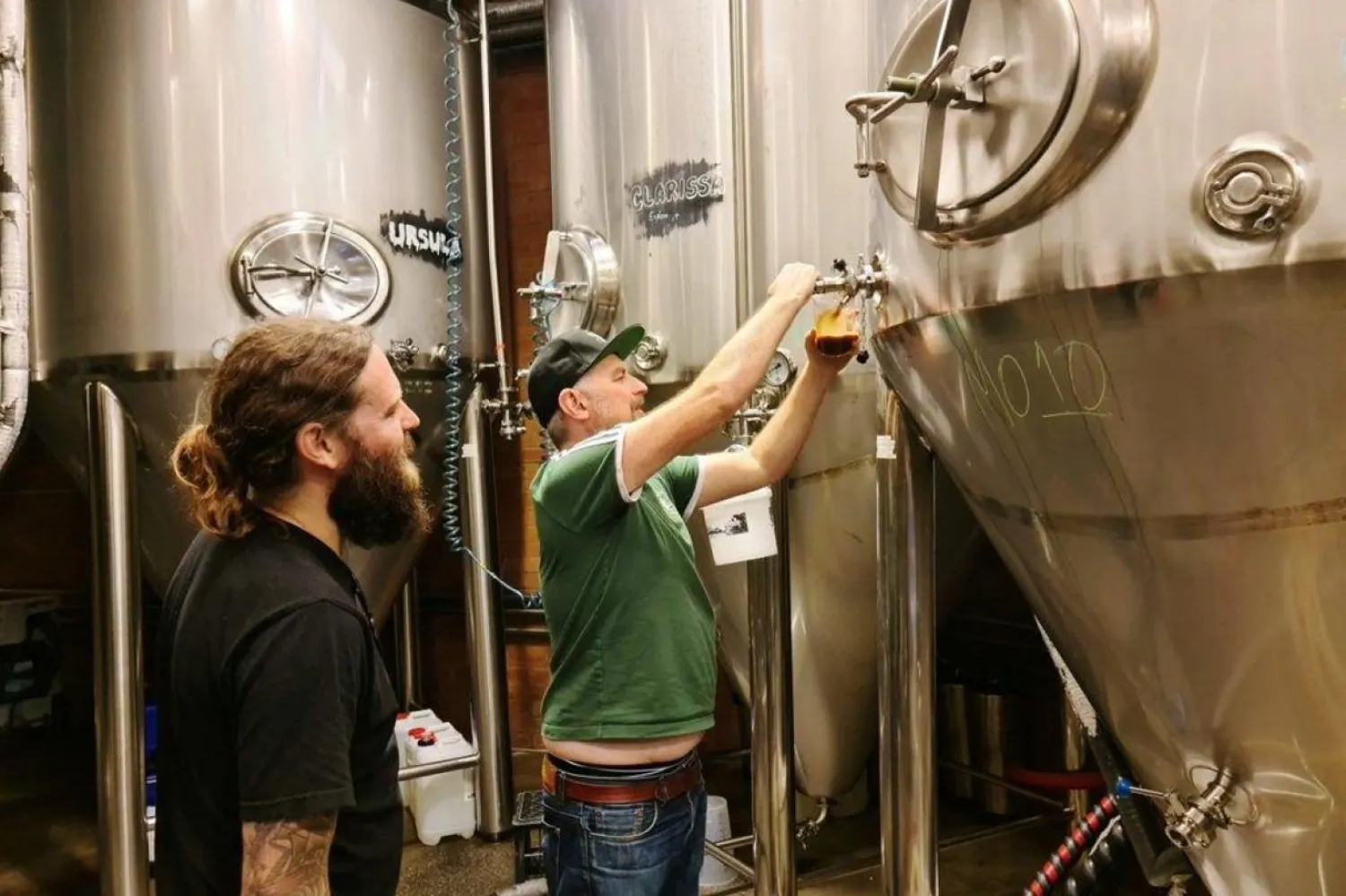 Young Henrys bira fabrikasının kurucuları Oscar McMahon (solda) ve Richard Adamson, Avustralya'nın Sidney kentindeki bira fabrikasında fermantasyon tanklarından bira dolduruyor (Reuters)

