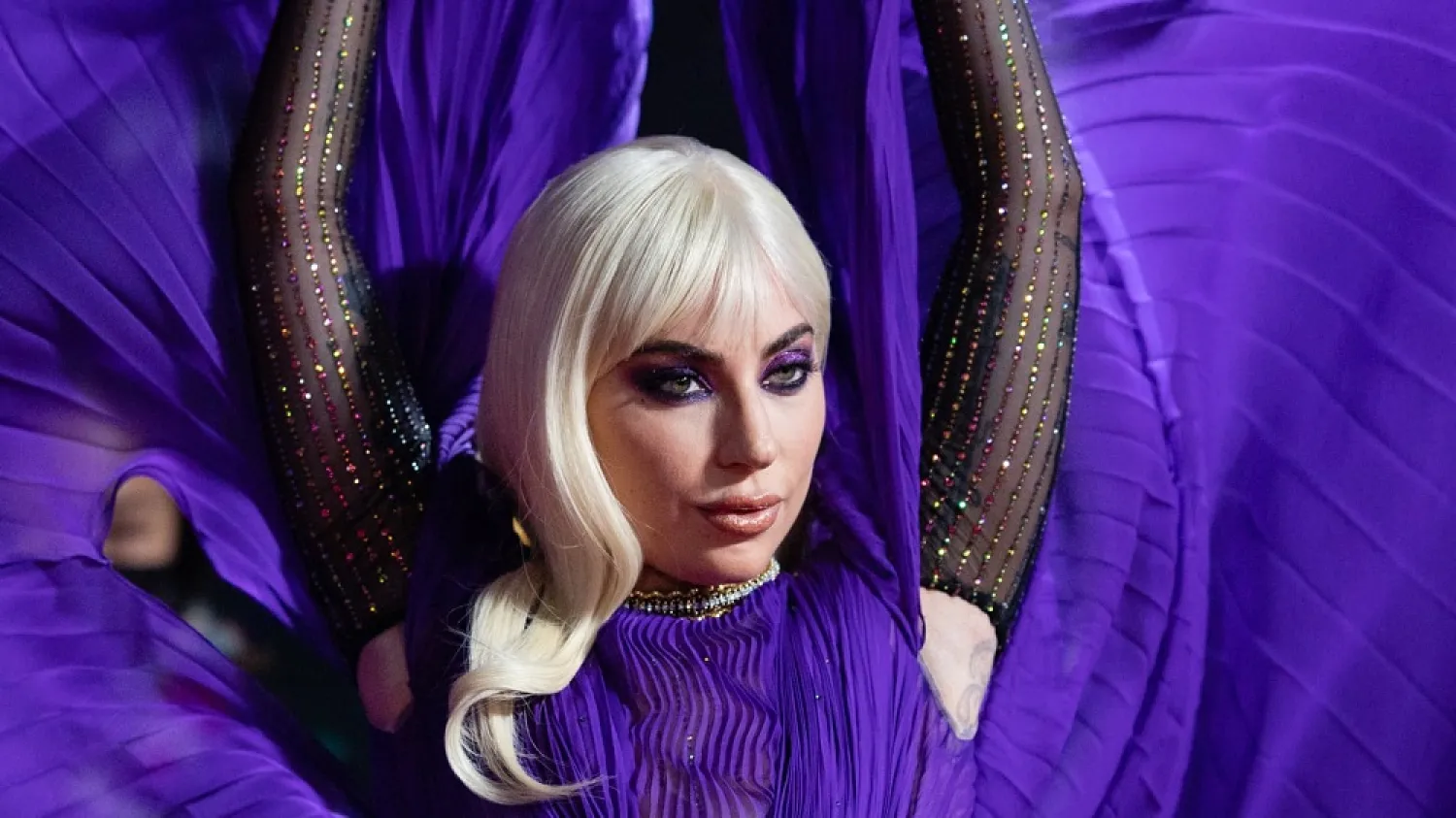 Lady Gaga stuns on the red carpet in a sheer, ultraviolet Gucci ensemble at the London premiere of "House of Gucci". (Getty Images)