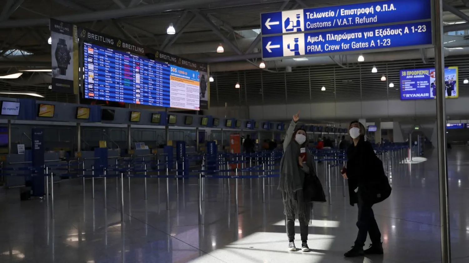 Passengers wearing protective face masks make their way at the Athens International airport, following an outbreak of the coronavirus disease, in Athens, Greece, March 21, 2020. (Reuters)
