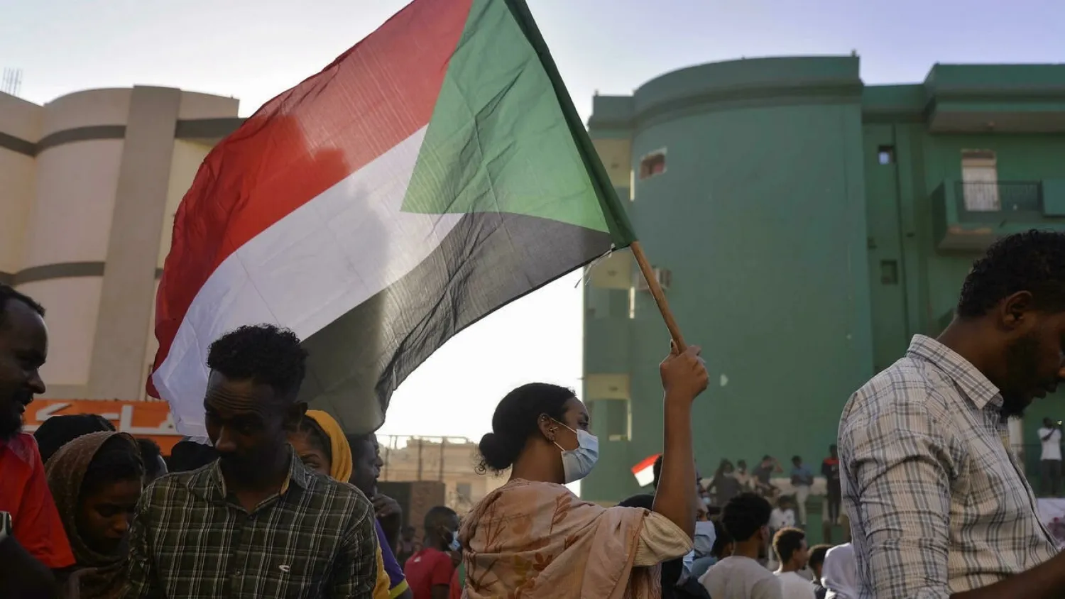 A Sudanese protester waves a flag during a rally in Khartoum following a deal-signing ceremony to restore the transition to civilian rule on November 21. (AFP)
