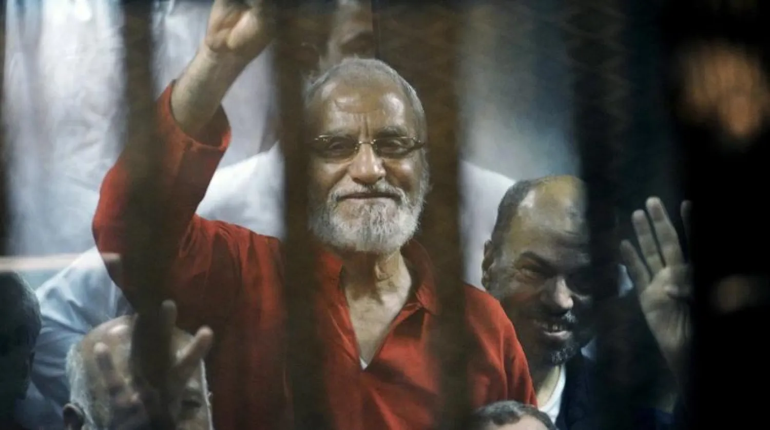 In this May 16, 2015 file photo, Muslim Brotherhood spiritual leader, Mohamed Badie waves from a defendants cage in a makeshift courtroom at the national police academy, in eastern Cairo, Egypt. (AP)