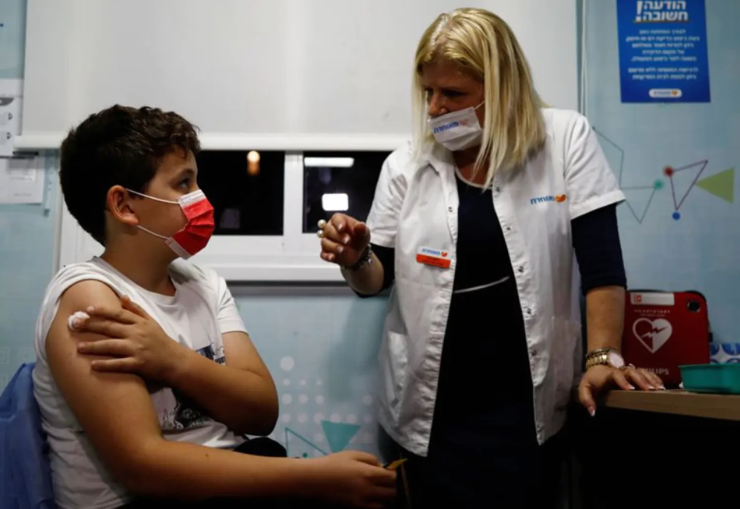 Noam Kleinmann, 10, chats with the nurse while he receives his first coronavirus disease (COVID-19) vaccination, in Tel Aviv, Israel November 22, 2021. REUTERS/Corinna Kern