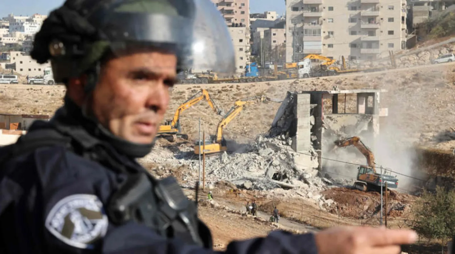 جندي إسرائيلي يقوم بالحراسة أثناء هدم منزل في المنطقة «أ» التابعة للسيادة الفلسطينية (أ.ف.ب)