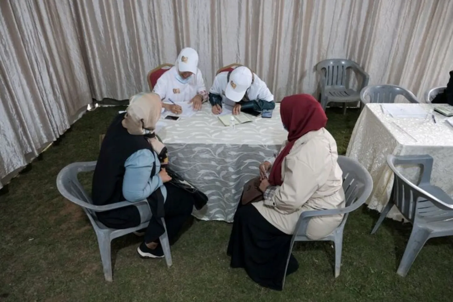 People sign papers to recommend the candidacy of Libya's LNA commander Khalifa Haftar in the presidential elections, in front of the Libya Karama Party headquarters, in Benghazi, Libya November 9, 2021. Picture taken November 9, 2021. (Reuters)