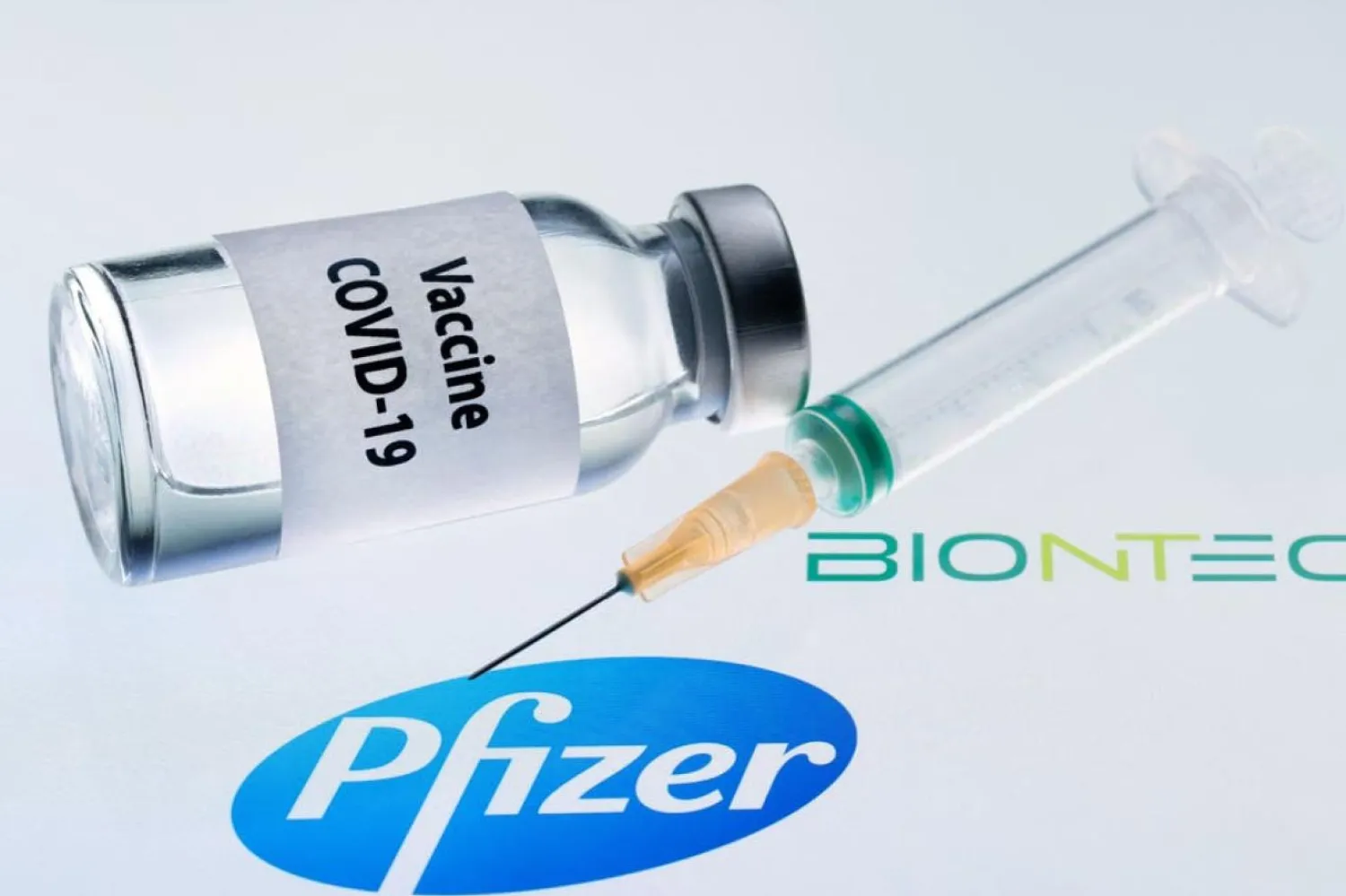 23 Kasım 2020 tarihli bu illüstrasyonda, üzerinde "Kovid-19 aşısı" yazan bir şişeyle Pfizer ve BioNTech logosunun yanında bir şırınga görülüyor (AFP)