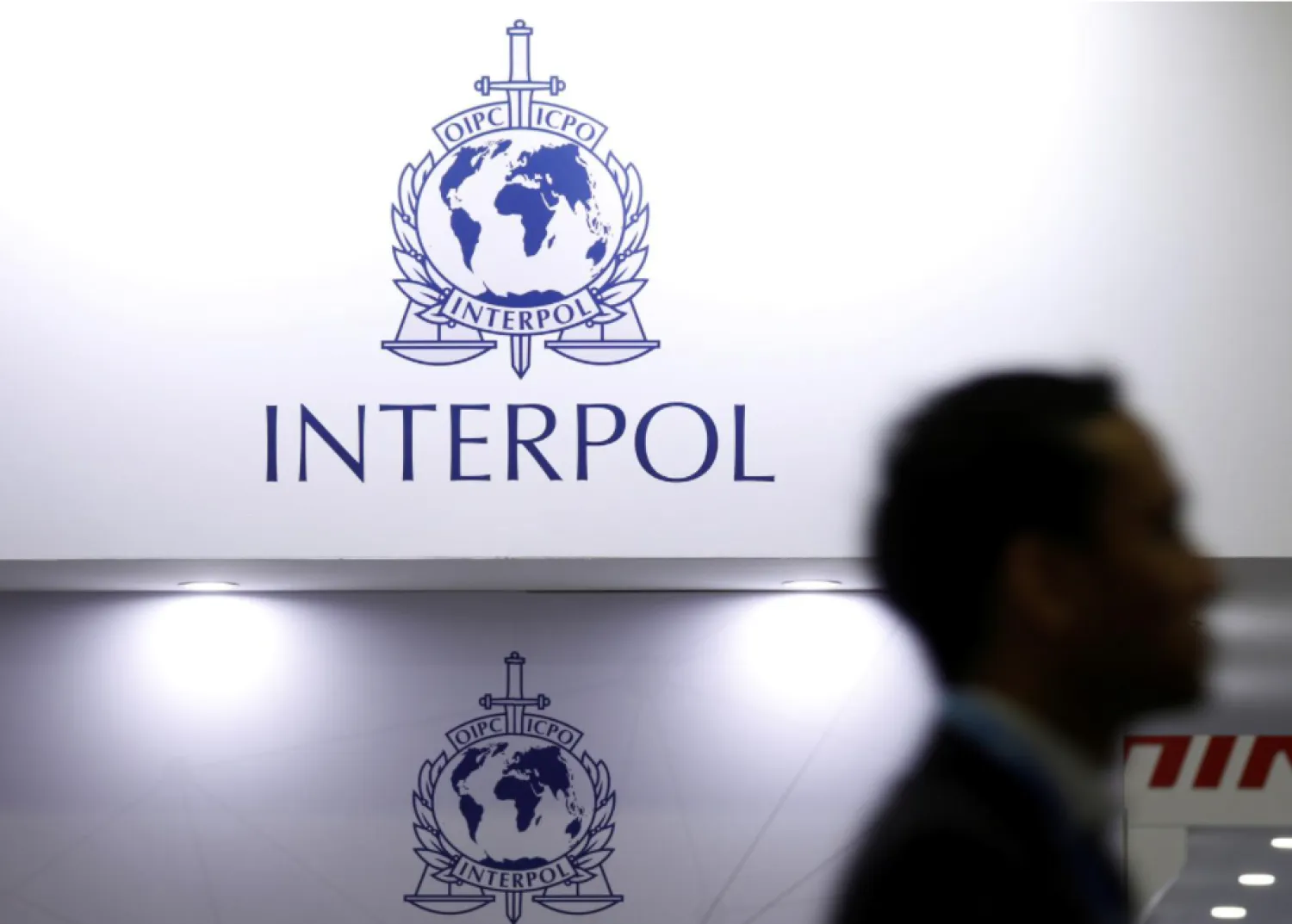 FILE PHOTO: A man passes Interpol signages at Interpol World in Singapore July 2, 2019. REUTERS/Edgar Su/File Photo
