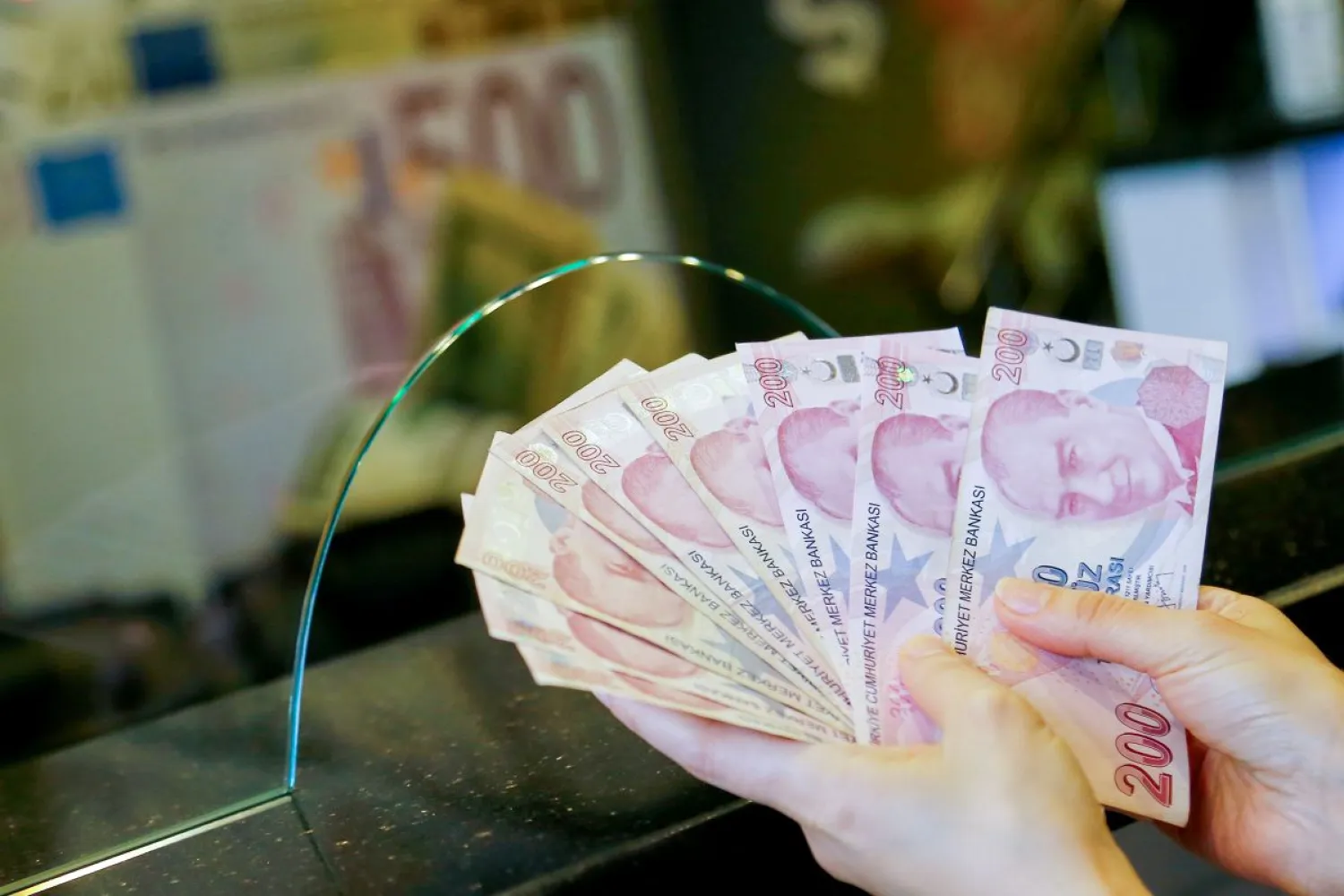A money changer holds Turkish lira banknotes at a currency exchange office in Ankara, Turkey September 27, 2021. (Reuters)