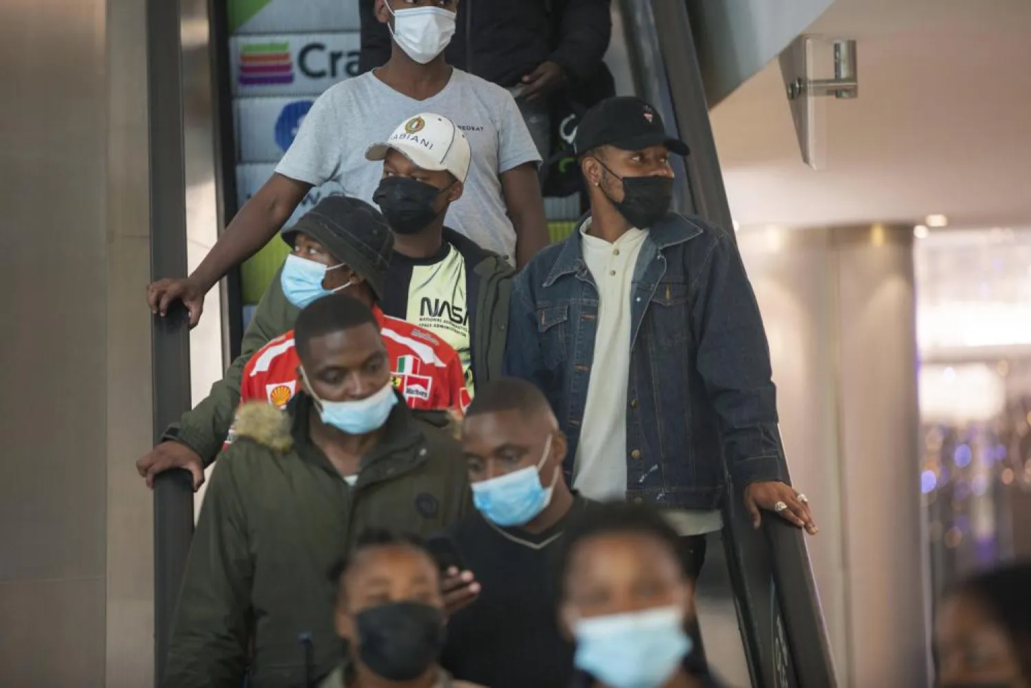 People wearing masks on an escalator at a shopping mall, in Johannesburg, South Africa, Friday Nov. 26, 2021. (AP)