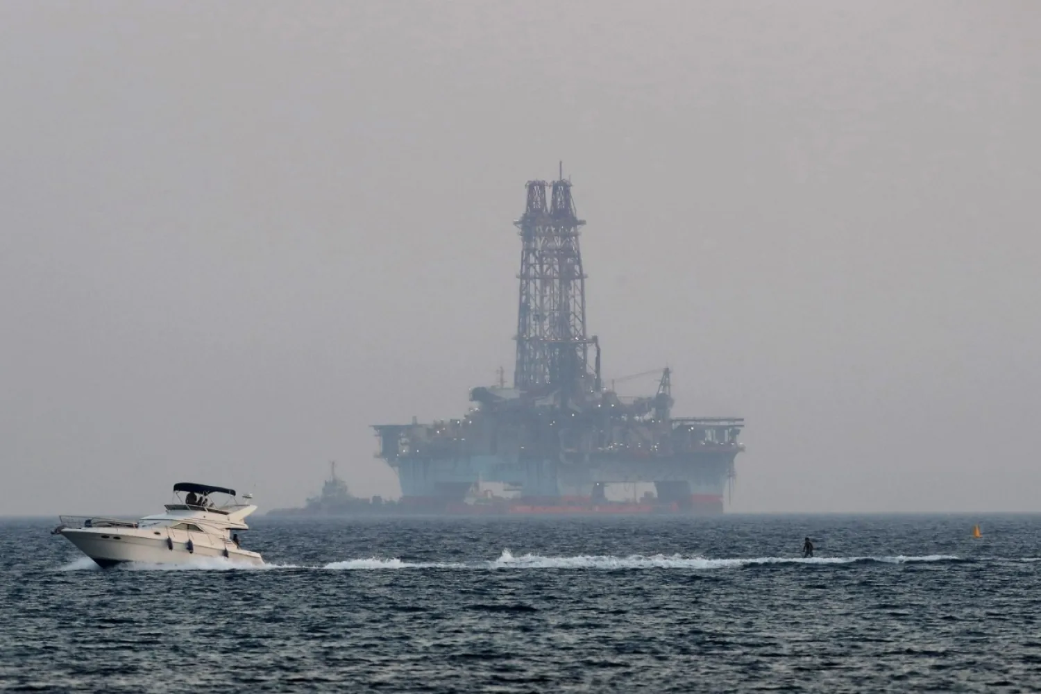 An offshore drilling rig is seen off Cyprus' coastal city of Limasol as a boat passes with a skier. (AP File Photo) 
