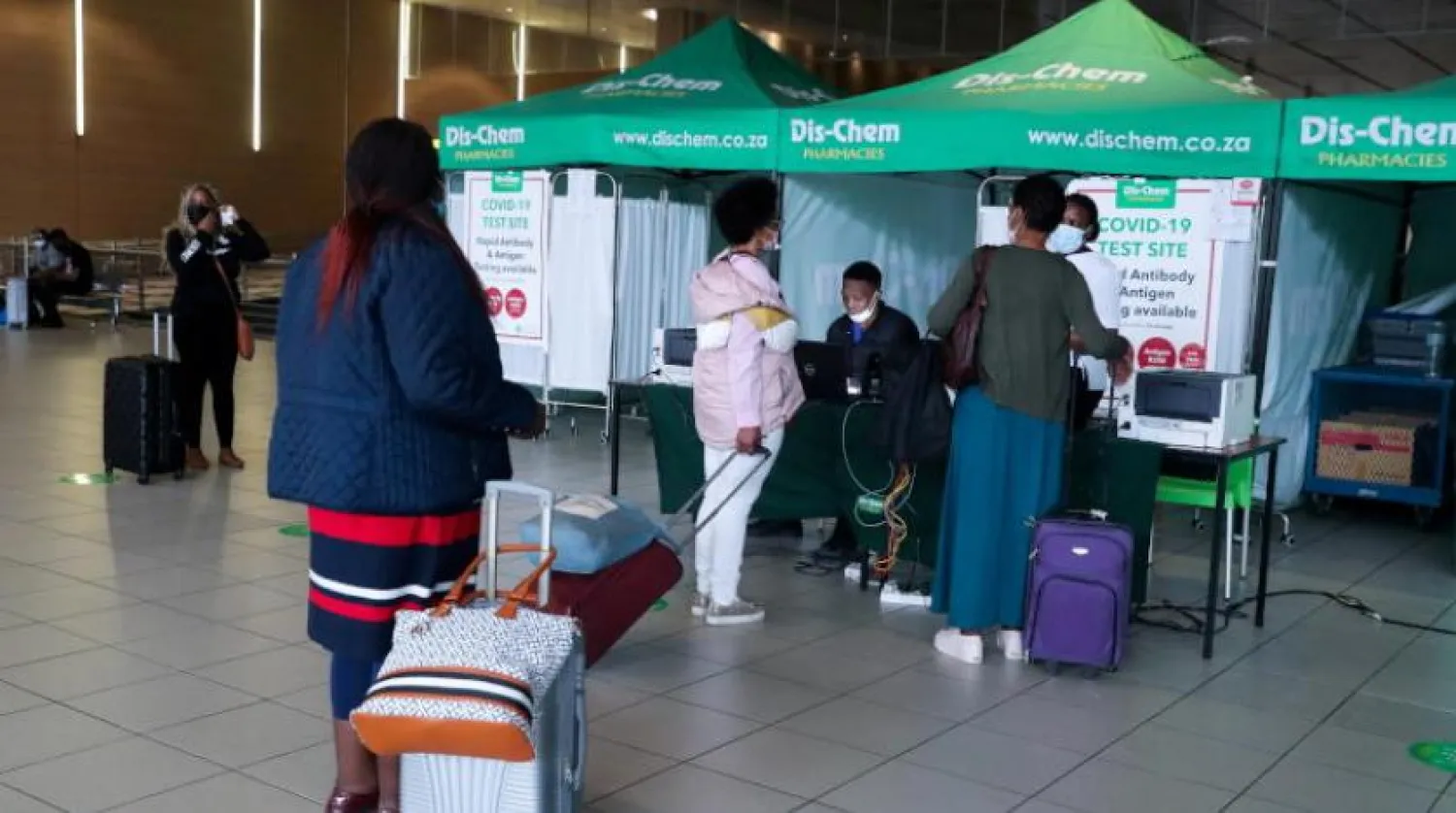 Yolcular Güney Afrika'daki bir havaalanında koronavirüs testi yaptırmak için sıra bekliyor (Reuters)