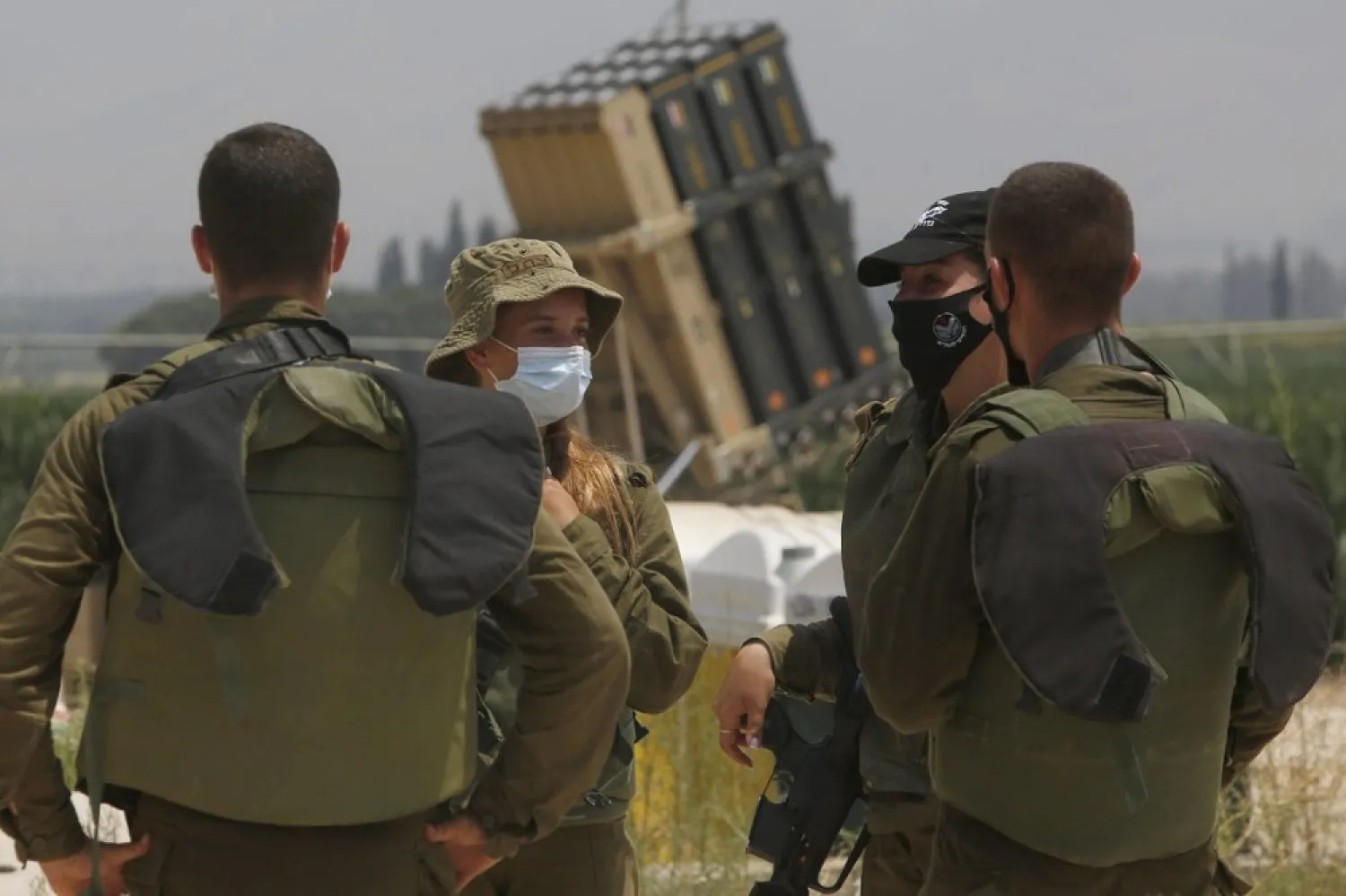 Israeli soldiers stand in front of an Iron Dome defense system battery in the Hula Valley (AFP/Getty Images)