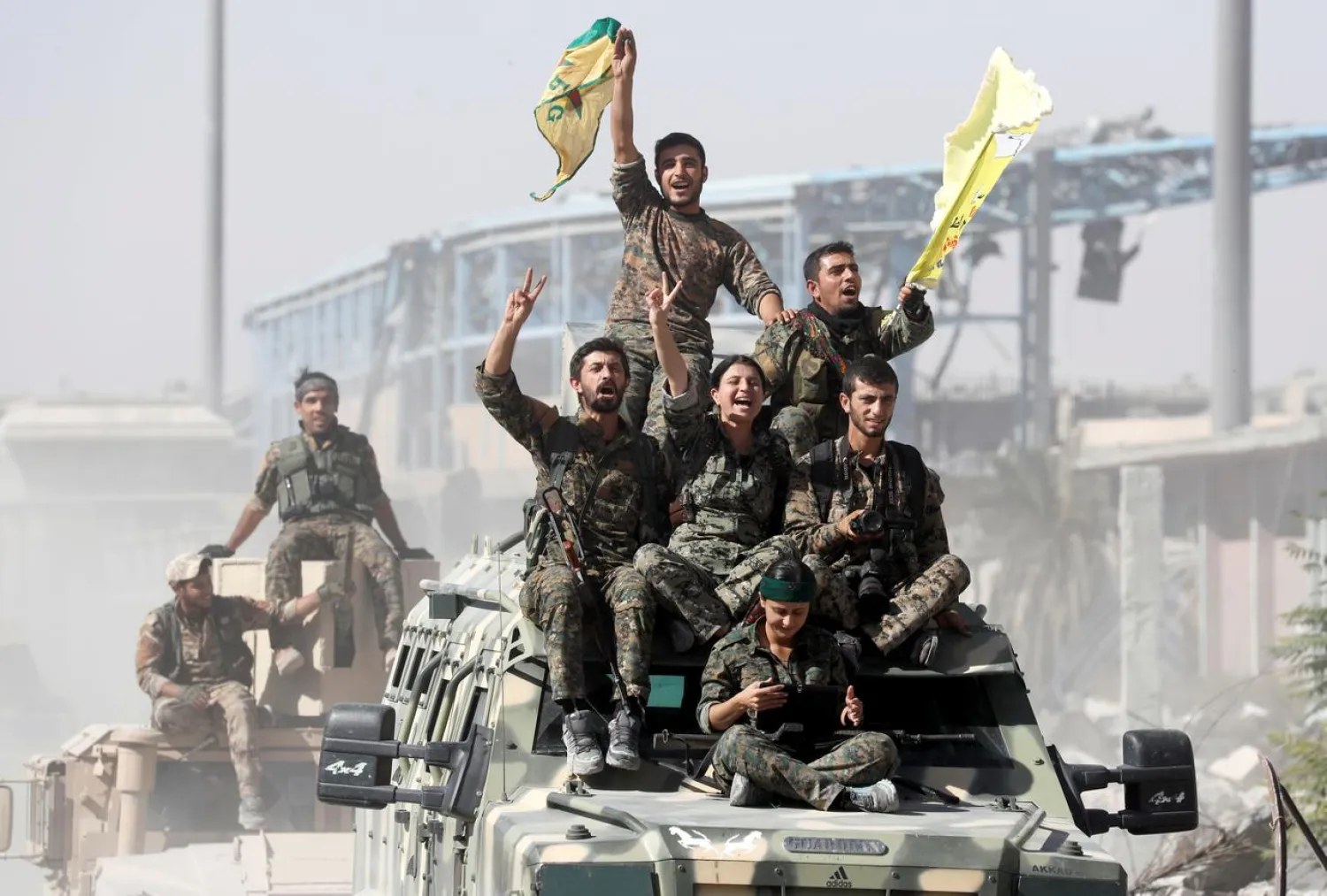 FILE PHOTO: Kurdish-led fighters ride atop military vehicles as they celebrate victory over ISIS in Raqqa, Syria, October 17, 2017. REUTERS/Erik De Castro/File Photo
