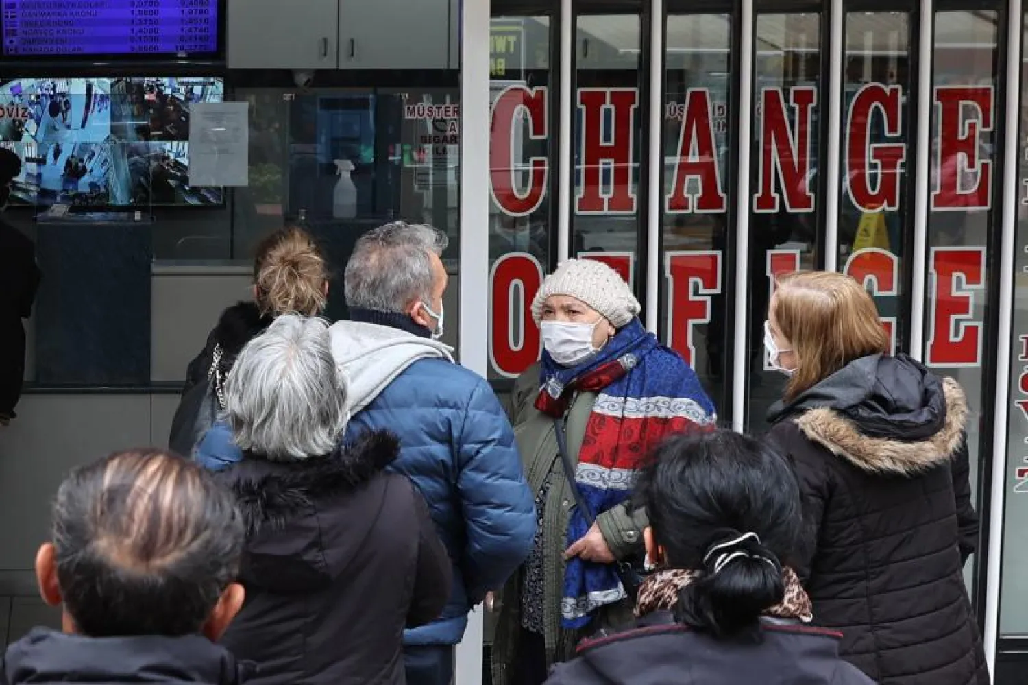 أشخاص يقفون أمام مدخل مكتب للصرافة في أنقرة (أ.ف.ب)