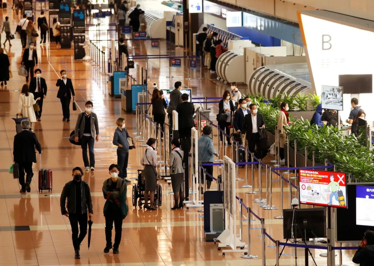Passengers wearing protective face masks are seen, amid the coronavirus disease (COVID-19) outbreak, at the Tokyo International Airport, commonly known as Haneda Airport in Tokyo, Japan October 23, 2020. REUTERS/Issei Kato