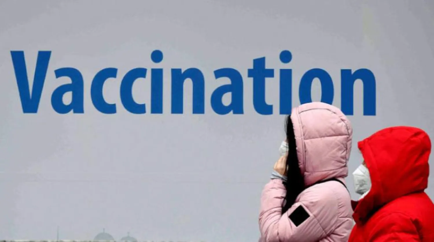 Omikron varyantından korkulurken Münih'teki bir afişte aşılama çağrısı yapılıyor (AFP)