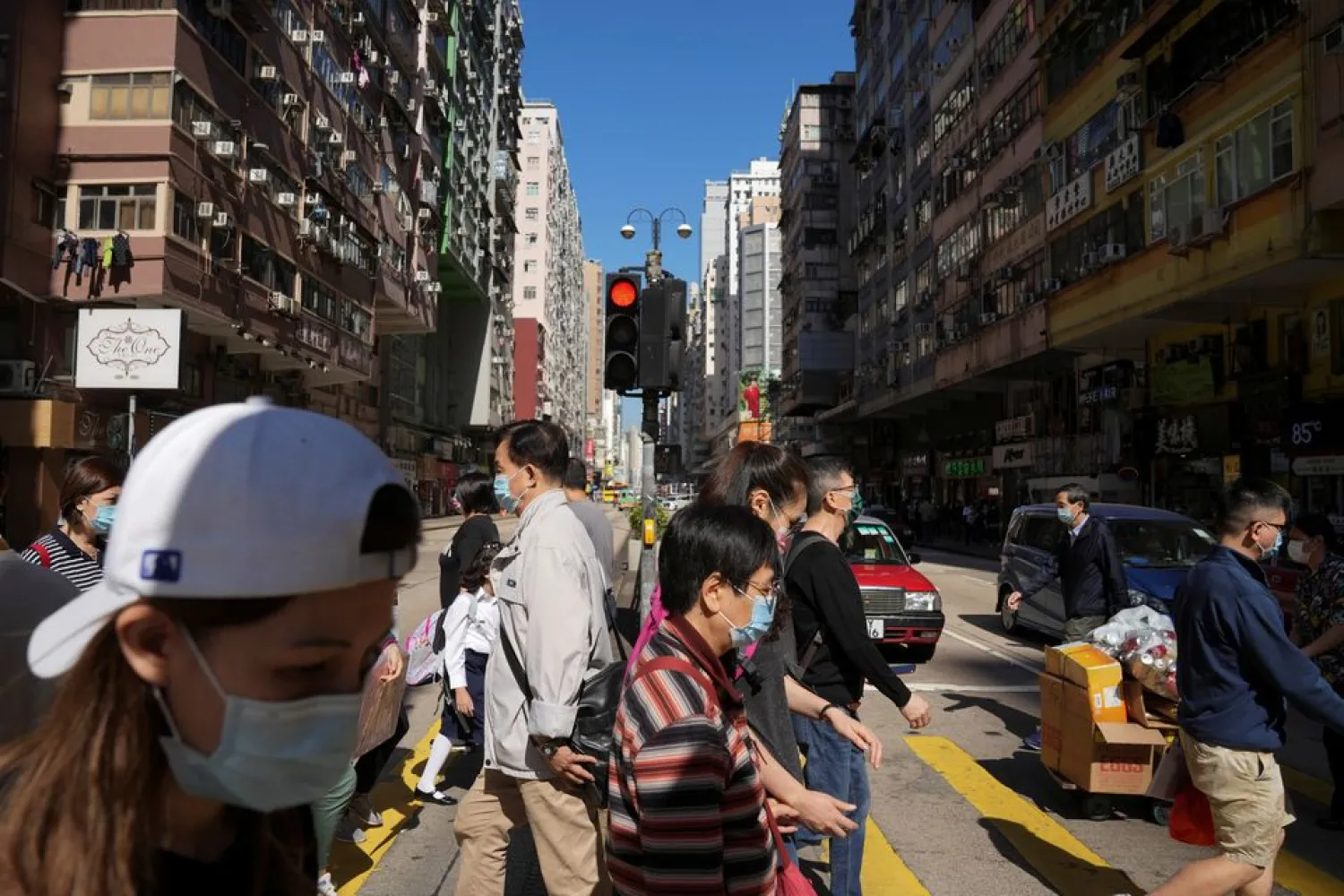 People wearing face masks to prevent the spread of the coronavirus disease (COVID-19), walk on a street in Hong Kong, China November 29, 2021. REUTERS/Lam Yik/file photo

