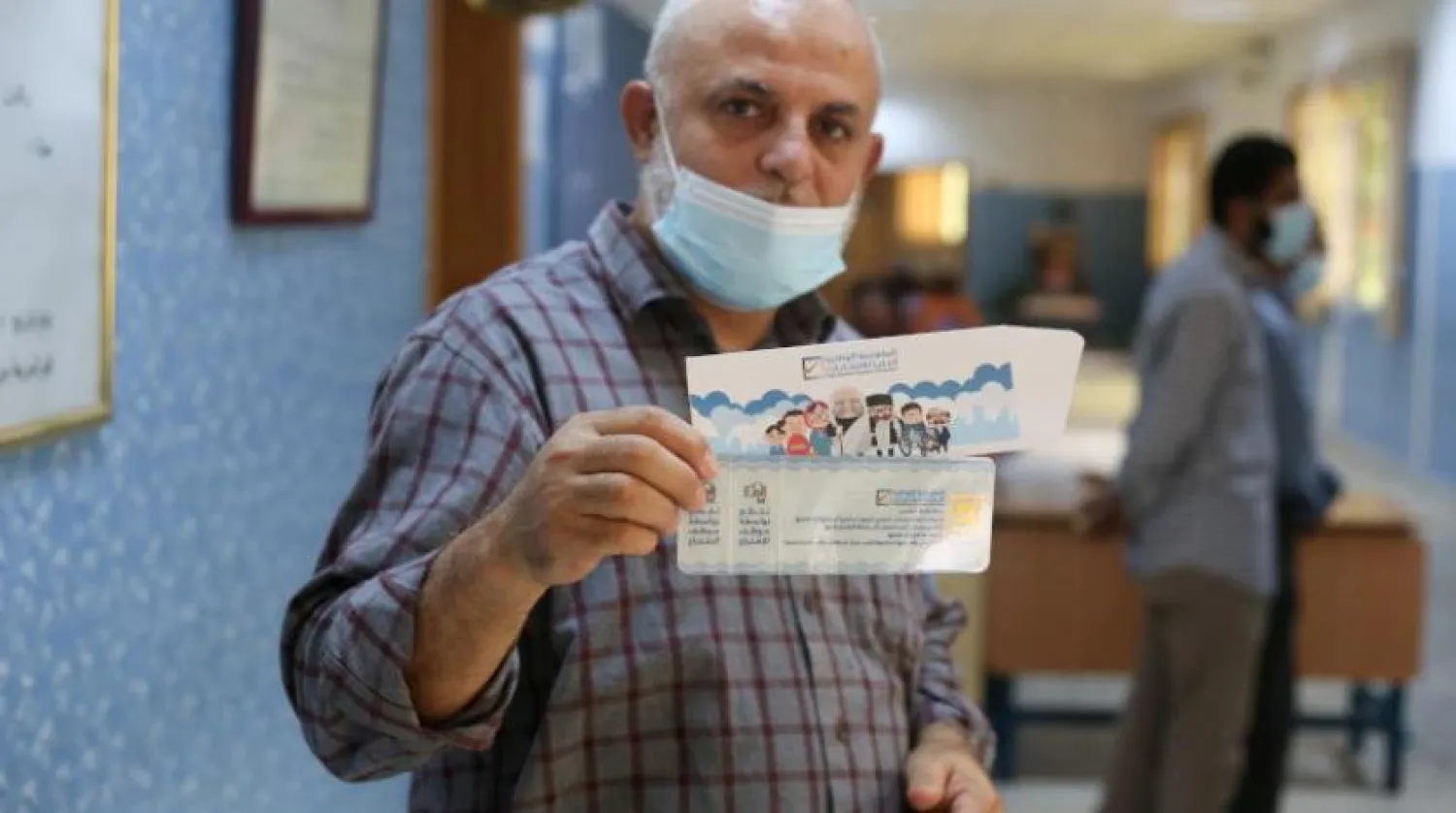 FILE PHOTO: A man shows the voter card he has received at a polling station in Tripoli, Libya November 8, 2021. REUTERS/Hazem Ahmed/File Photo