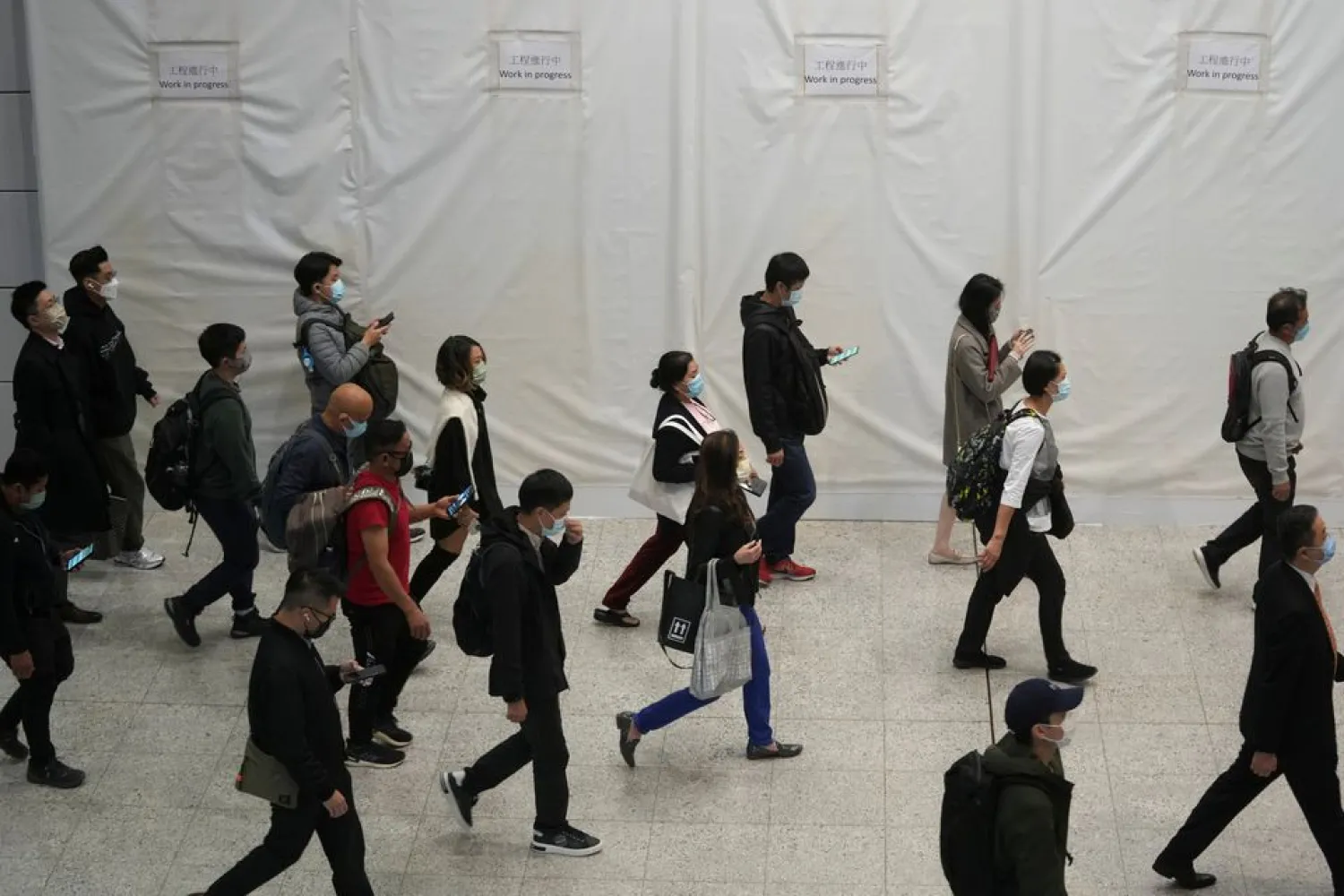 Passengers wearing masks to prevent the spread of the coronavirus disease (COVID-19), walk at a subway station in Hong Kong, China December 1, 2021. (Reuters)