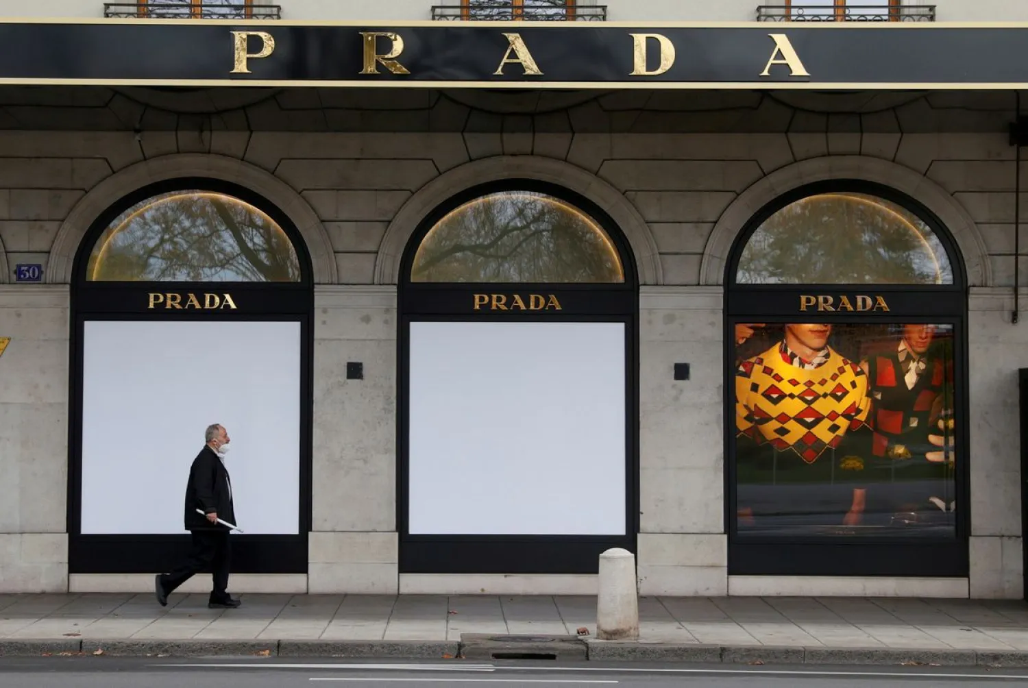 A man walks past a closed Prada shop in Geneva, Switzerland, November 16, 2020. REUTERS/Denis Balibouse