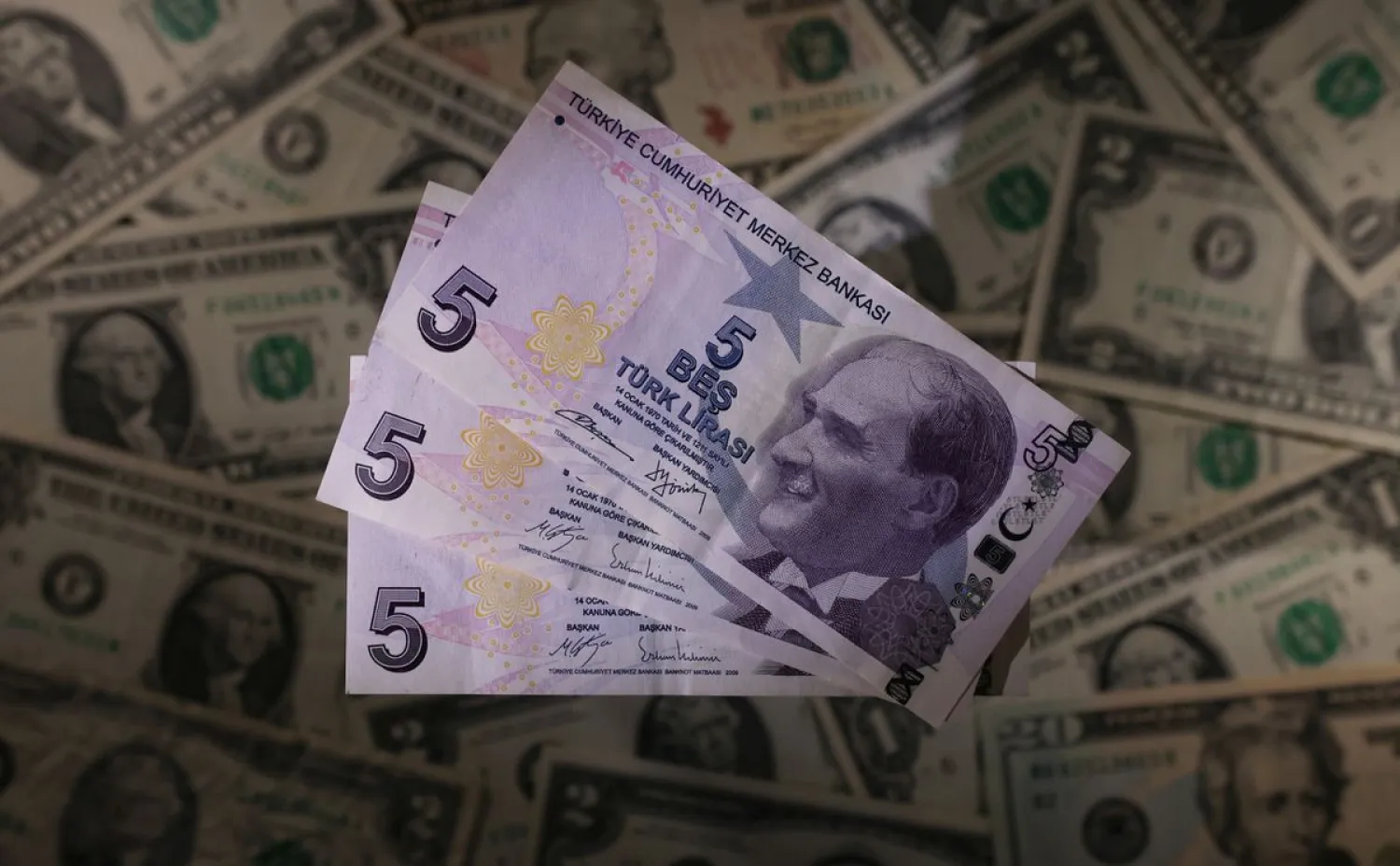 Turkish lira banknotes are seen placed on US Dollar banknotes in this illustration taken, November 28, 2021. (Reuters)