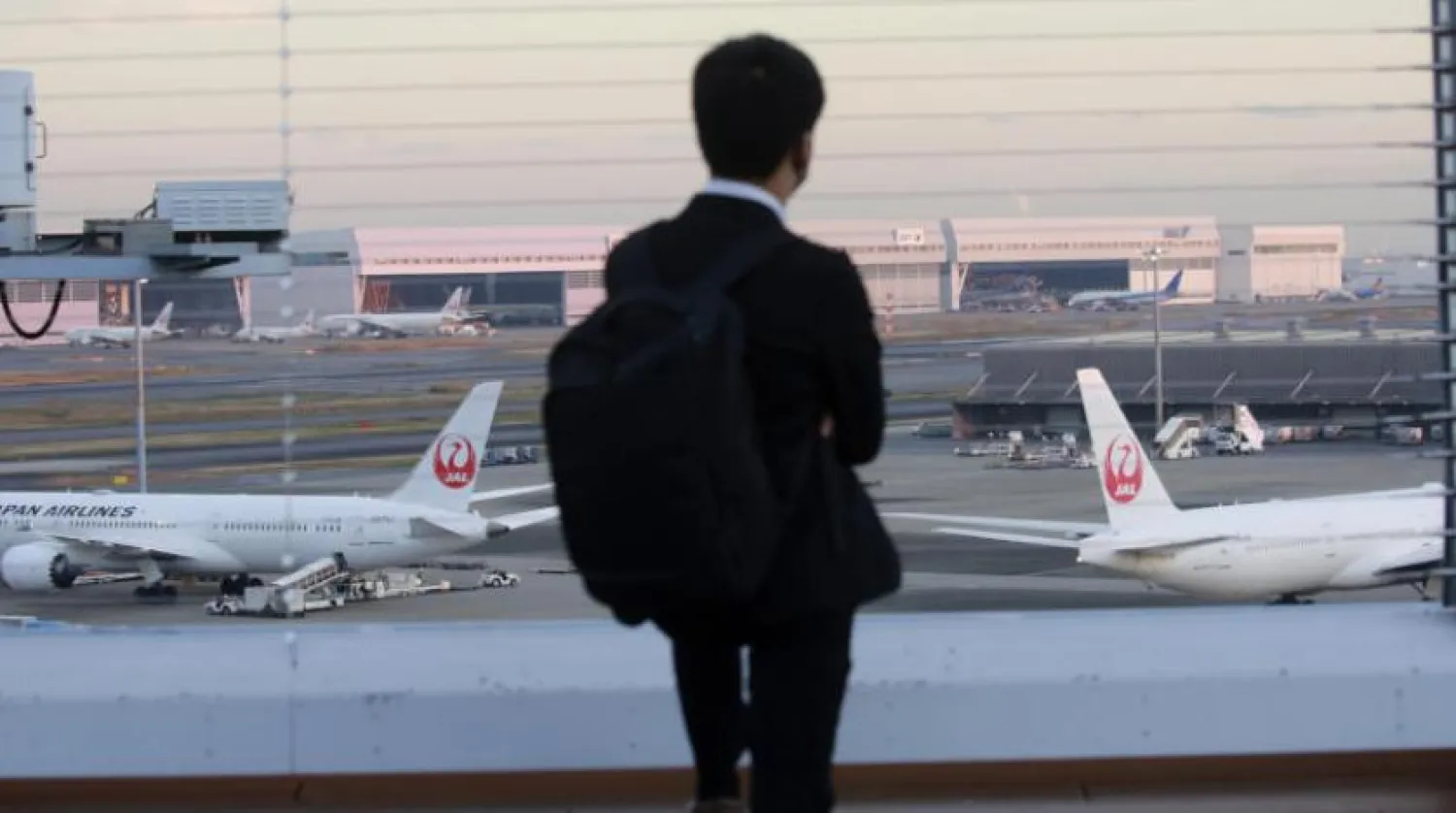 Bir adam Tokyo Uluslararası Havalimanı'nda Japan Airlines uçağına bakıyor  (AP)
