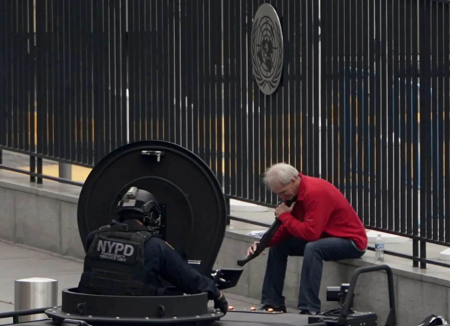 الرجل المسلح يصوّب البندقية إلى ذقنه والشرطة تراقبه (رويترز)