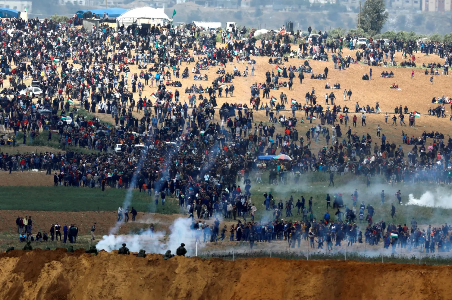 Israeli soldiers shoot tear gas from the Israeli side of the Israel-Gaza border, as Palestinians protest on the Gaza side of the border, March 30, 2018. (Reuters File Photo)