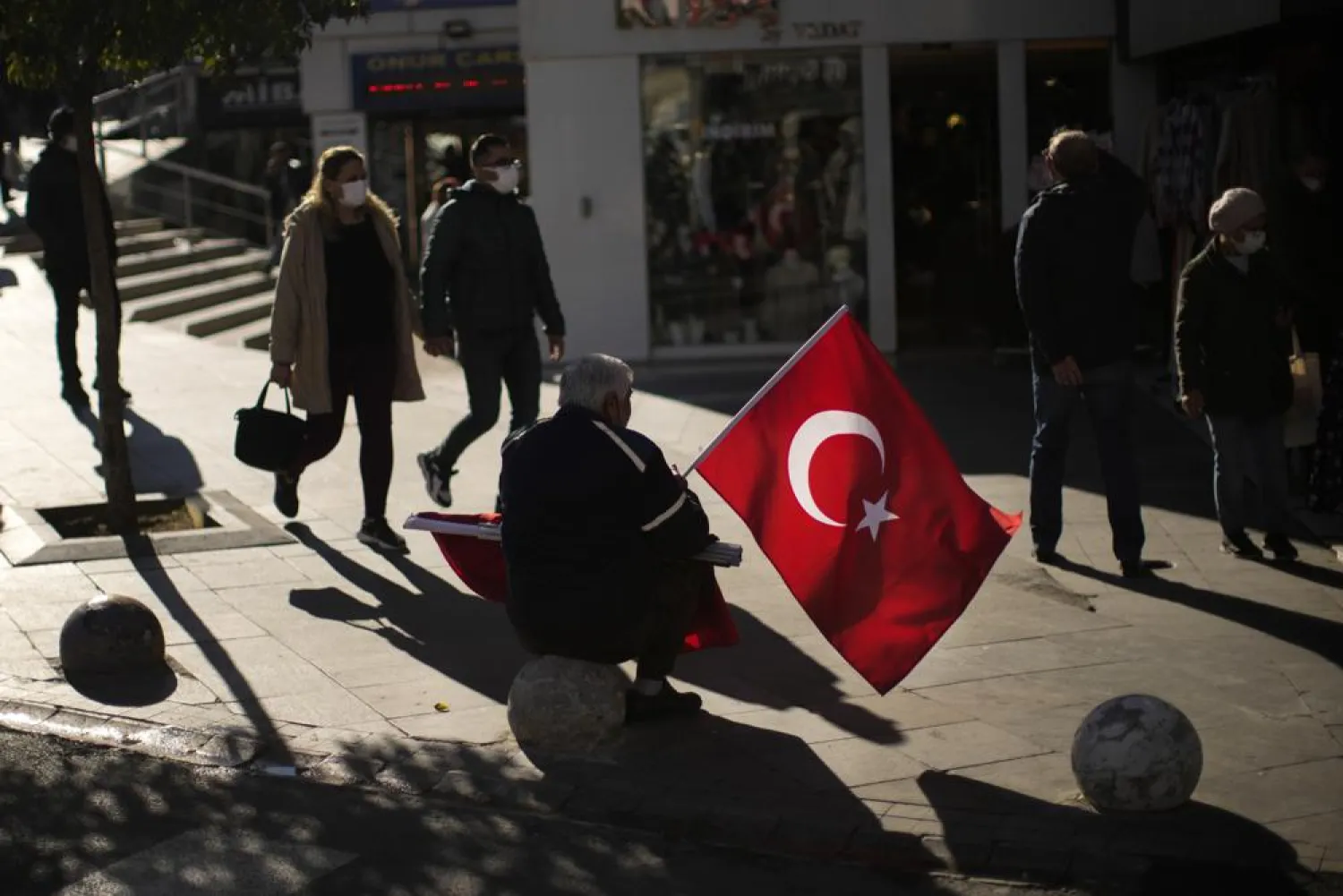 A man sells Turkish flags in a commercial area in Kadikoy neighborhood in Istanbul, Turkey, Thursday, Dec. 2, 2021.  (AP Photo/Francisco Seco)
