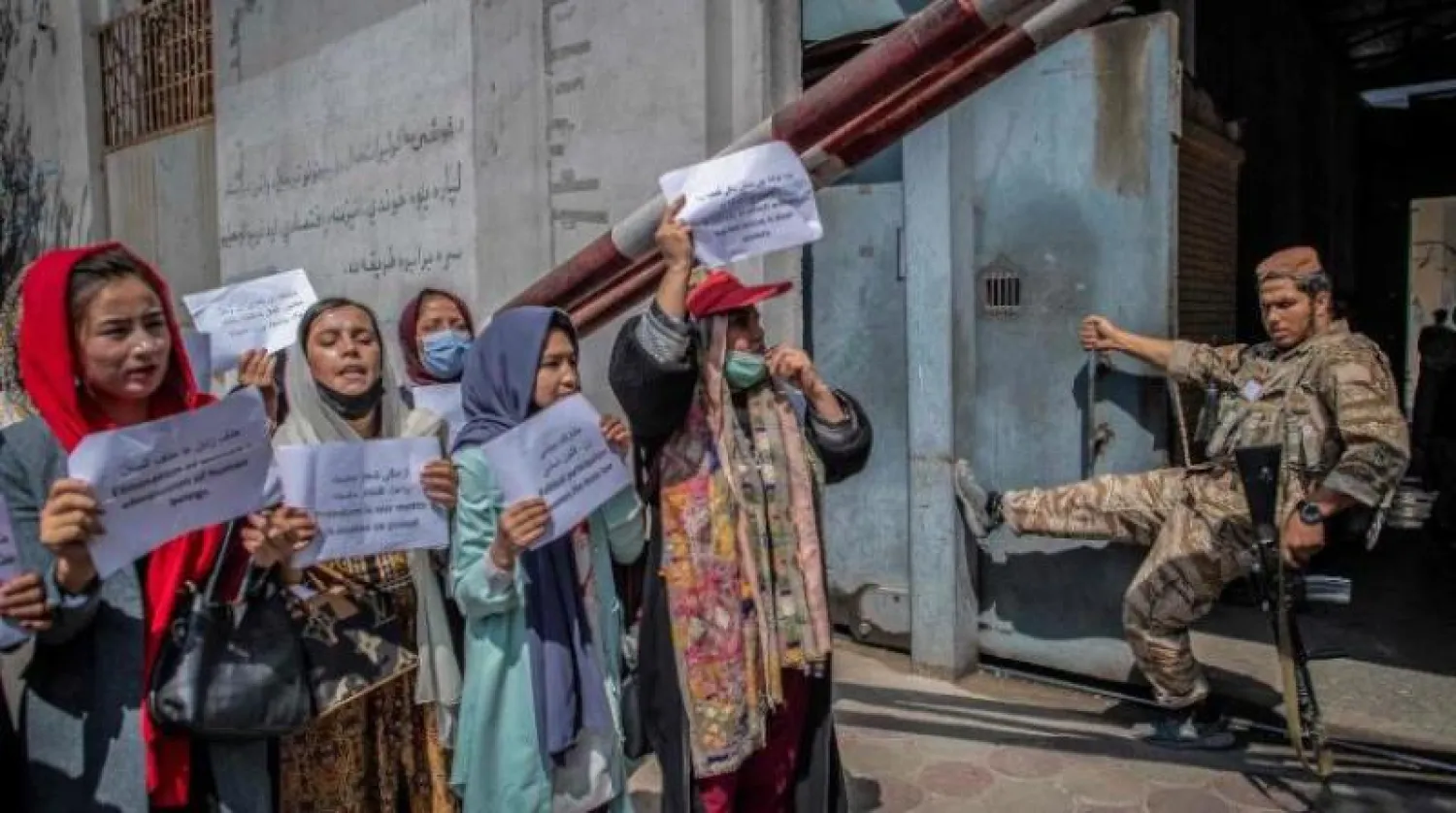 أفغانيات يتظاهرن أمام مقاتل من «طالبان» في محيط وزارة شؤون المرأة سابقاً (أرشيفية - أ.ف.ب)