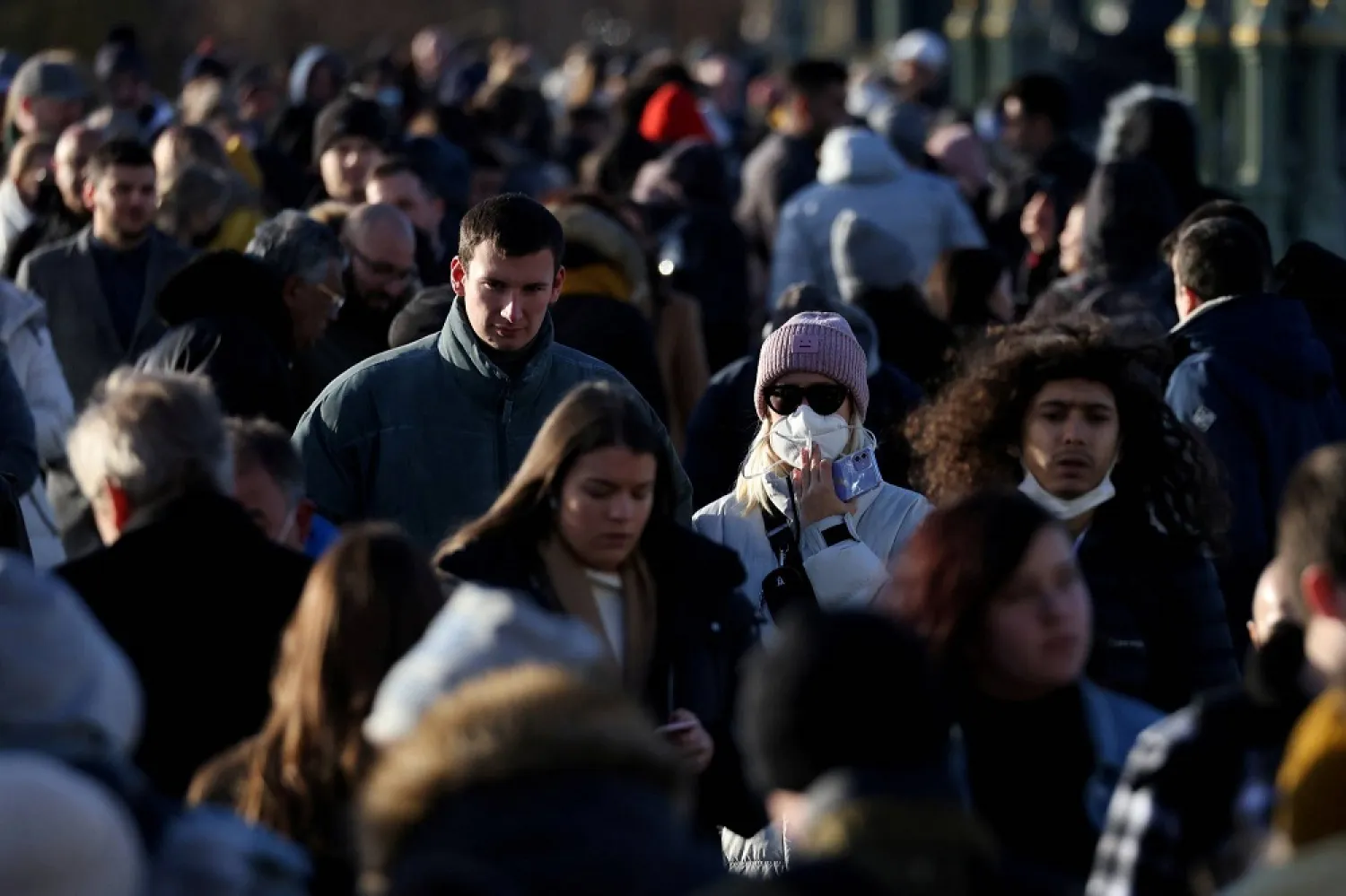People walk across Westminster Bridge in London on Sunday after new measures were announced due to the Omicron coronavirus variant. (Reuters)