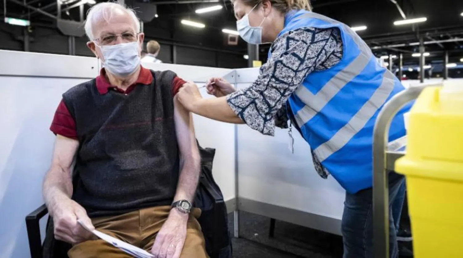 Hollanda’da yaşlı bir kişiye Kovid-19 karşıtı aşı yapılırken (EPA)