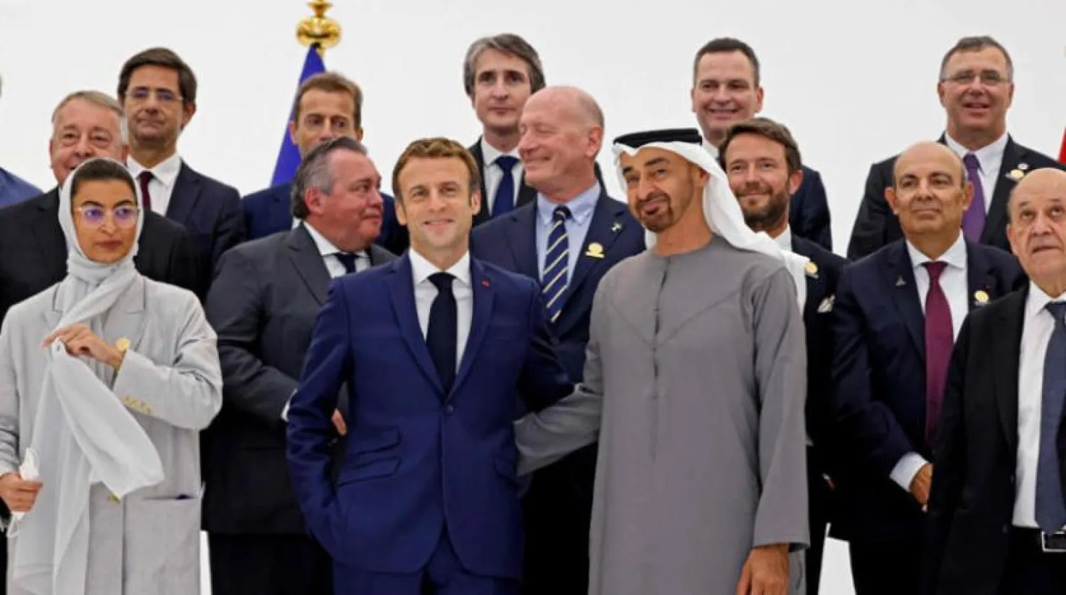 French President Emmanuel Macron (C-L) and Abu Dhabi's Crown Prince Mohammed bin Zayed al-Nahyan prepare for a group picture during his tour of the French pavilion at the Dubai Expo on the first day of his Gulf tour on December 3, 2021. (Photo by Thomas SAMSON / AFP)