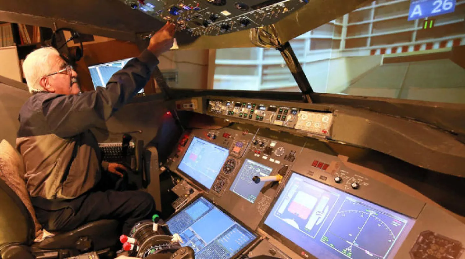 محمد ملحس جالساً في قمرة القيادة التي بناها في قبو منزله في عمان (أ.ف.ب)