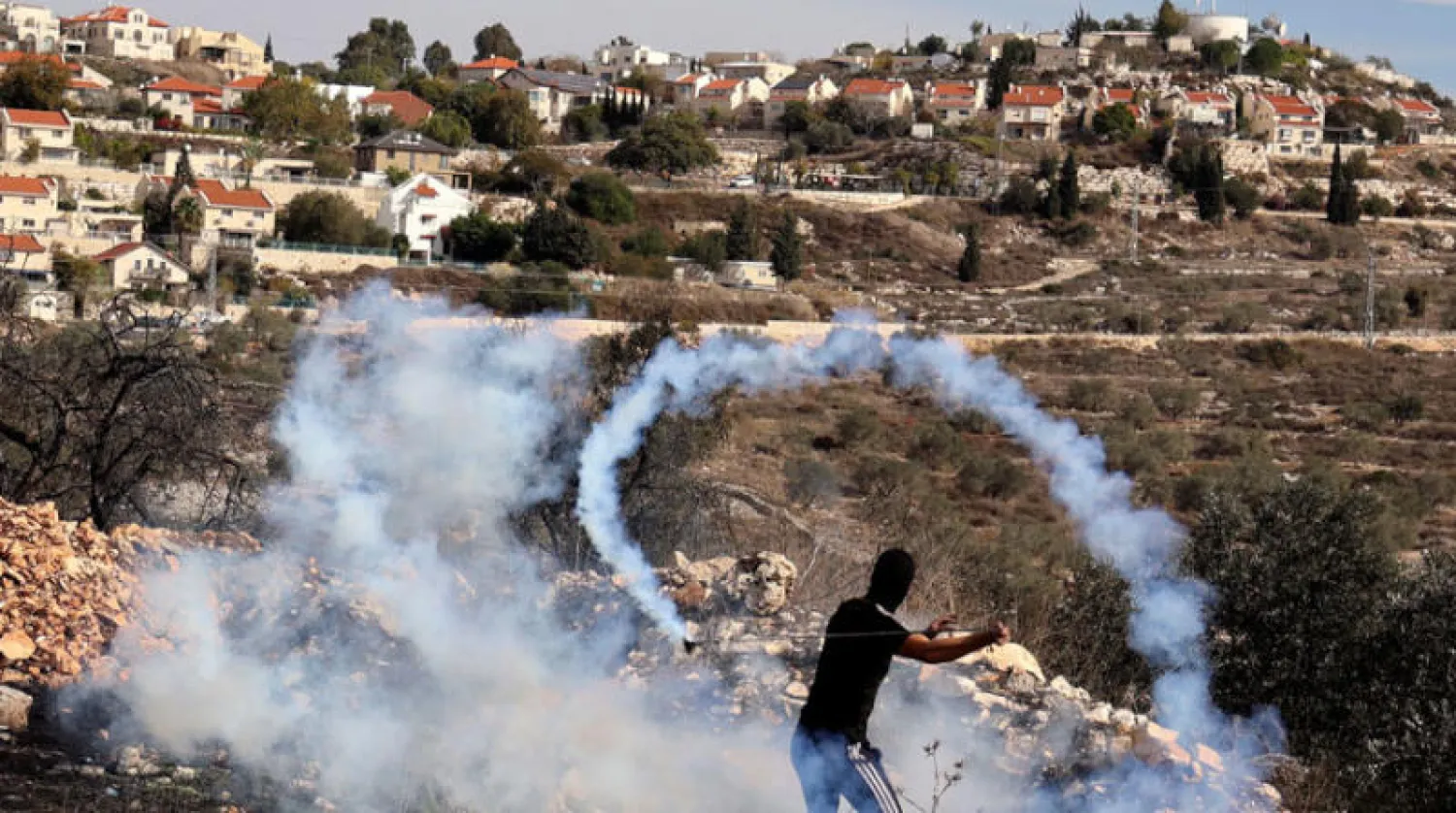 محتج فلسطيني خلال اشتباكات مع قوات إسرائيلية ضد الاستيطان في قرية كفر قدوم بالضفة (أ.ف.ب)