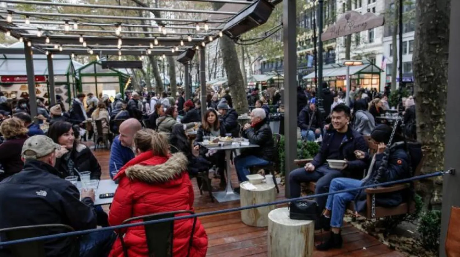 ABD’deki Bryant Park’ta maskesiz oturan insanlar (AFP)