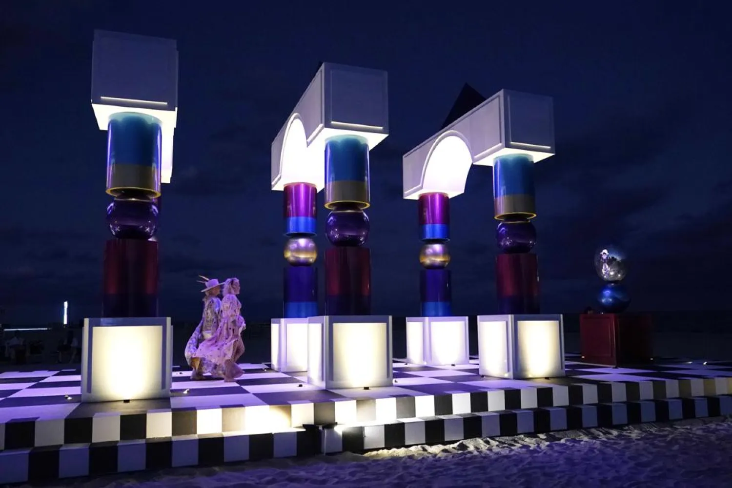 People walk through an art installation titled, "Hall of Visions," by artist Pilar Zeta of Argentina, on the beach at the Faena Hotel during Miami Art Week, Tuesday, Nov. 30, 2021, in Miami Beach, Fla. (AP)