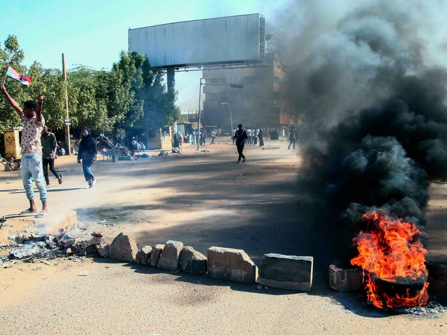 Sudanese demonstrators block a road with bricks and burning tyres during a rally in the capital Khartoum, on December 6, 2021, to protest a deal that saw the prime minister reinstated after his ouster in a military coup in October. (AFP)