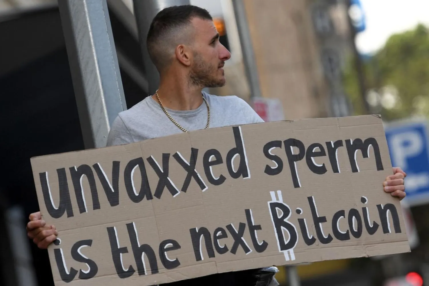 ABD'nin Florida eyaletindeki Melbourne kentinde aşı zorunluluğuna ve pandemi uygulamalarına karşı 4 Aralık'ta gerçekleştirilen eylemde bir protestocu "Unvaxxed Sperm yeni Bitcoin" pankartı taşımıştı (AFP)