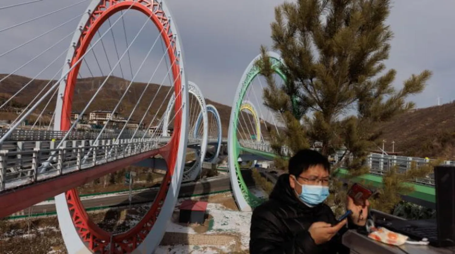 Bir teknisyen, Zhangjiakou’daki Pekin Olimpiyat tesislerine giden bir otoyolda elektrik kutusu üzerinde çalışıyor (Reuters)