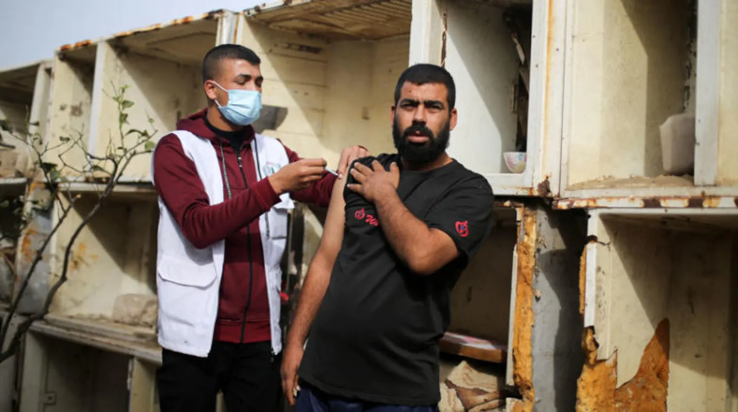 تطعيم ضد كورونا في أحد الأبنية التي تنتظر إعادة الإعمار في قطاع غزة (رويترز)