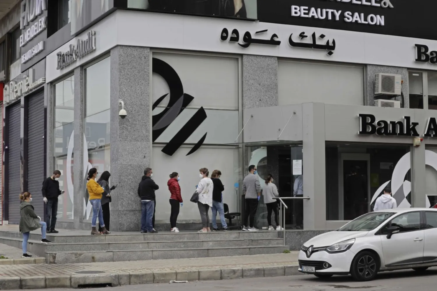 Mask-clad clients queue outside a bank in the Zalka suburb of Beirut, Lebanon. (AFP file photo)