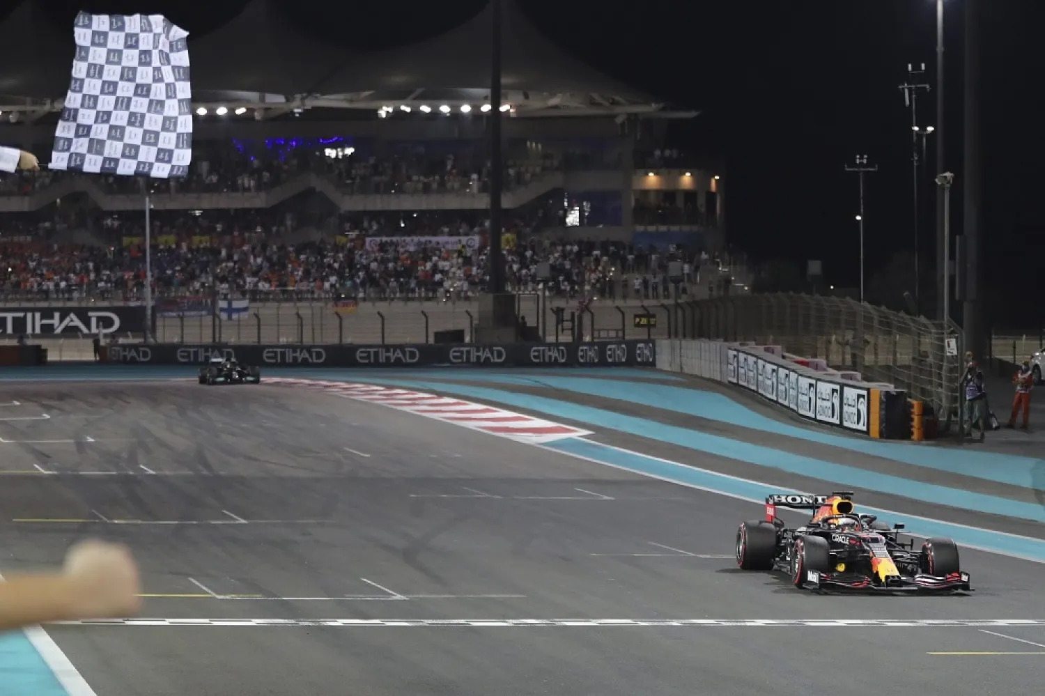  Red Bull's Dutch driver Max Verstappen (R) crosses the finish line to win the 2021 Abu Dhabi Grand Prix and the F1 world championship at Yas Marina Circuit, Abu Dhabi, UAE, Dec. 12, 2021. (EPA)