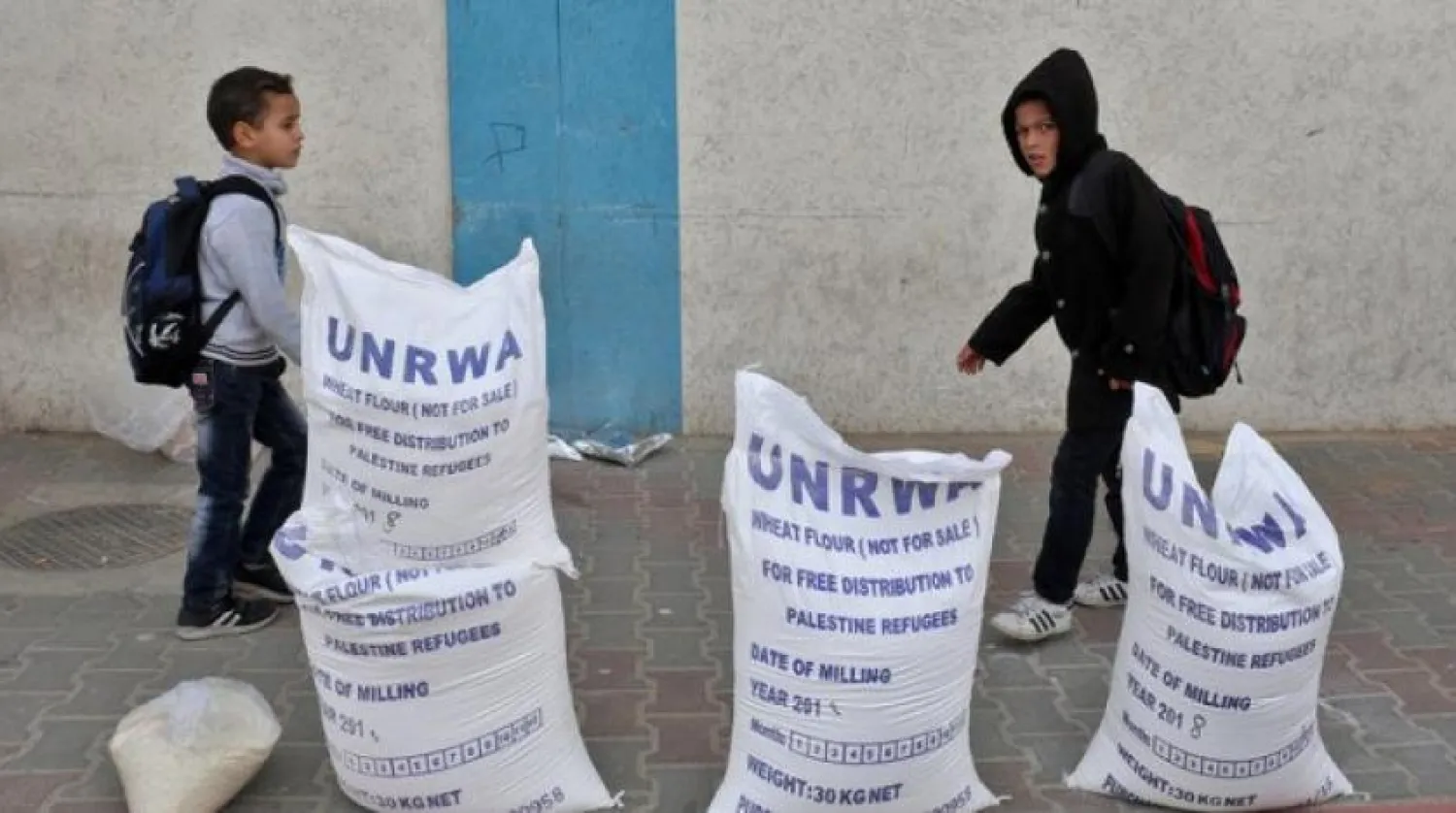 Palestinians receive aid from UNRWA. (AFP/File)