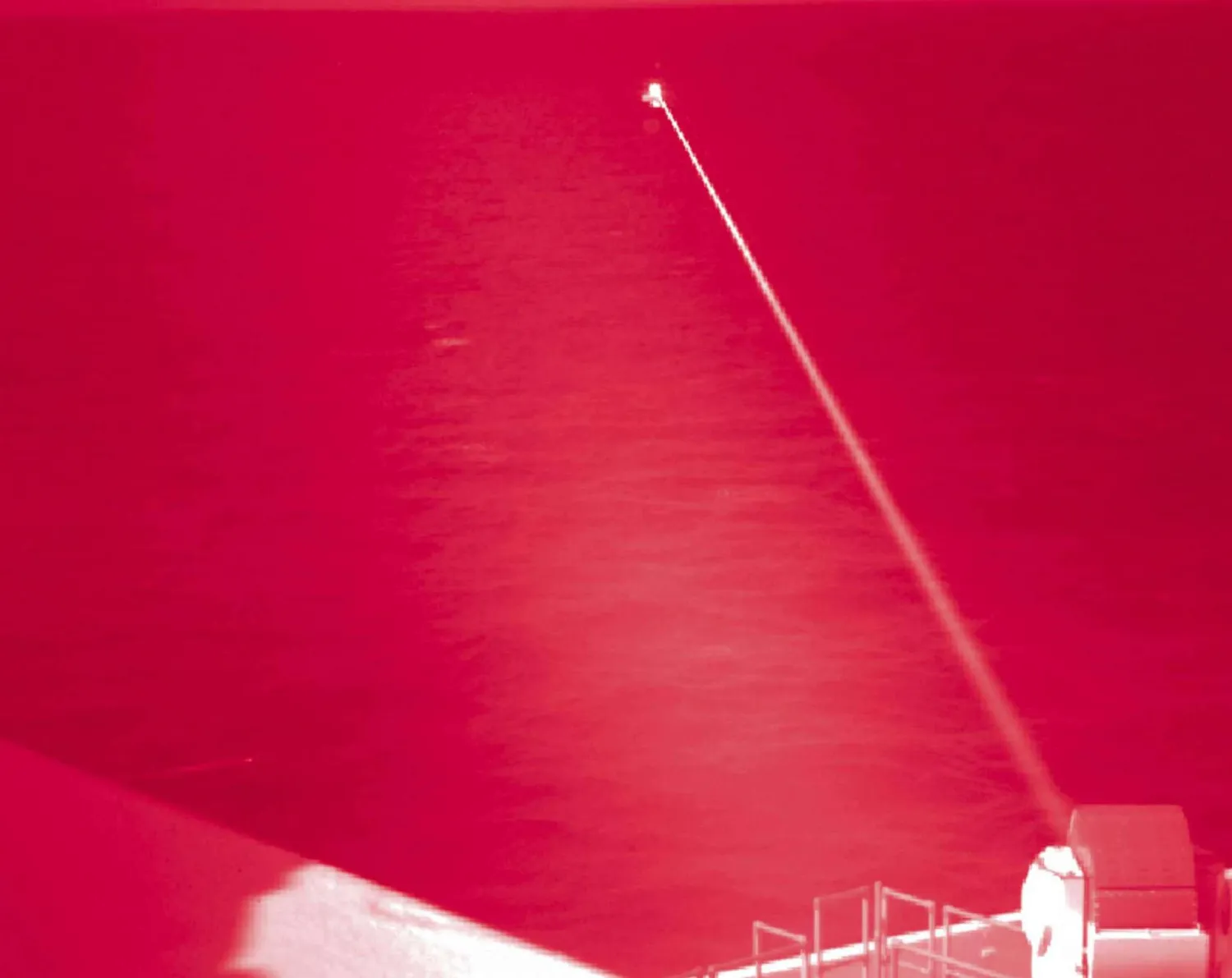 In this handout infrared photo from the US Navy, the USS Portland fires a laser weapon system at a target floating in the Gulf of Aden on Tuesday, Dec. 14, 2021. (Mass Communication Specialist 2nd Class Devin Kates/US Marine Corps via AP)