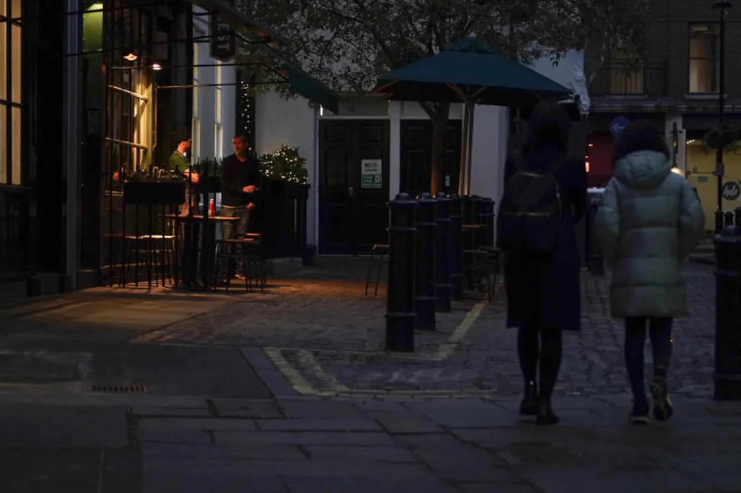 أشخاص يقفون خارج مطعم في لندن (أ.ب)