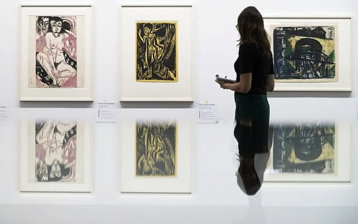 A visitor watches the paintings 'Melancholisches Maedchen' (left) and Nackte Frau im Walde" of German painter Ernst Ludwig Kirchner, in the exhibition 'Status Report Gurlitt. degenerate art - confiscated and sold' in the Kunstmuseum in Bern, Switzerland, on Wednesday, November 1, 2017. (Peter Klaunzer/Keystone via AP)
