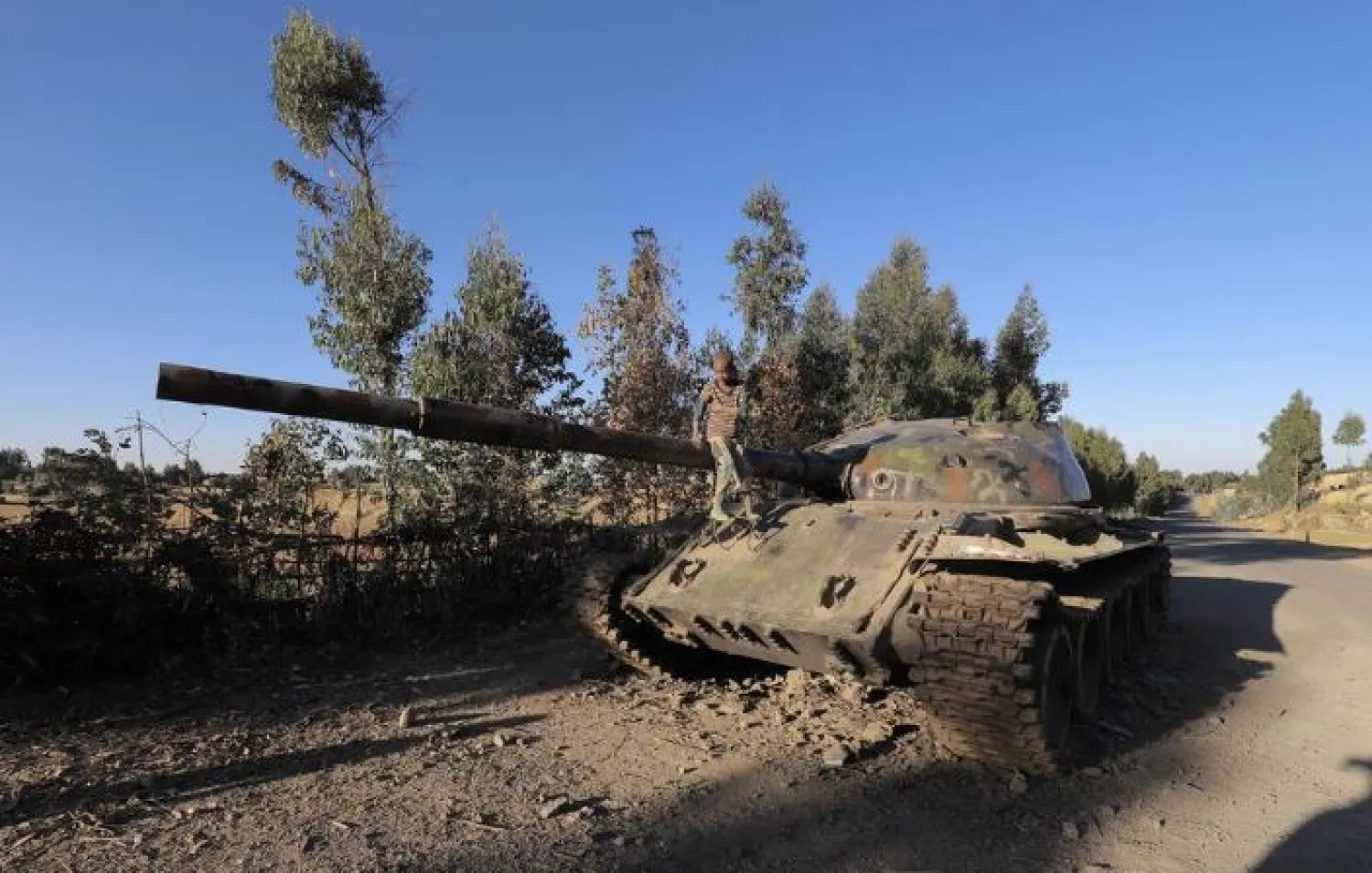A boy sits on the barrel of a military tank destroyed recently during fighting between the Ethiopian National Defense Force (ENDF) and the Tigray People's Liberation Front (TPLF) in Damot Kebele of Amhara region, Ethiopia December 7, 2021. REUTERS/Kumera Gemechu

