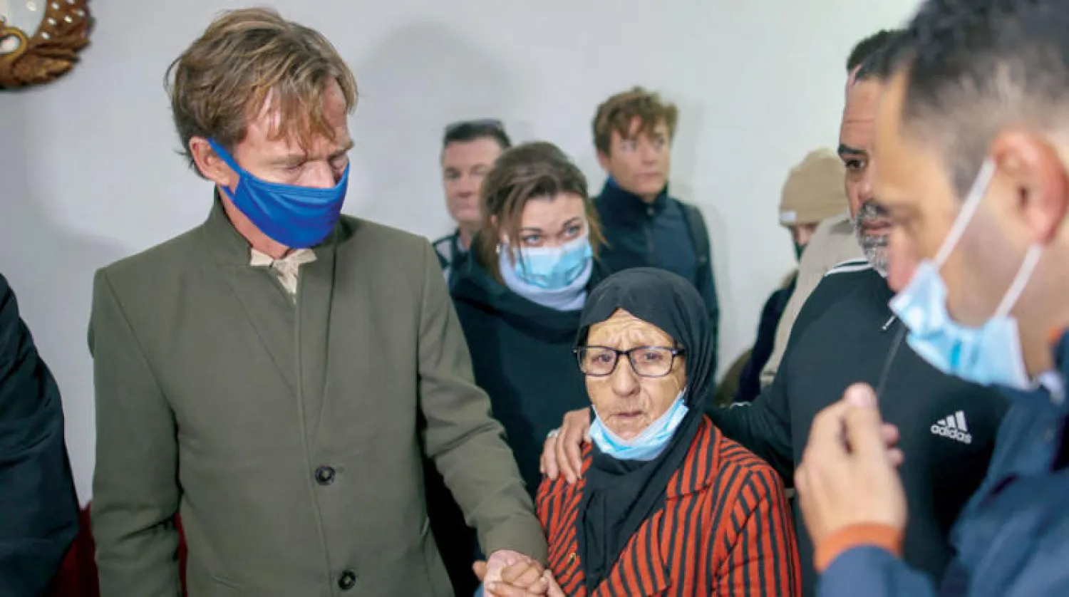 فاطمة سالم تمسك بيد سفين بورغسدورف رئيس بعثة الاتحاد الأوروبي خلال زيارة لمنزلها في حي الشيخ جراح بعد تبليغها بالإخلاء (أ.ف.ب)